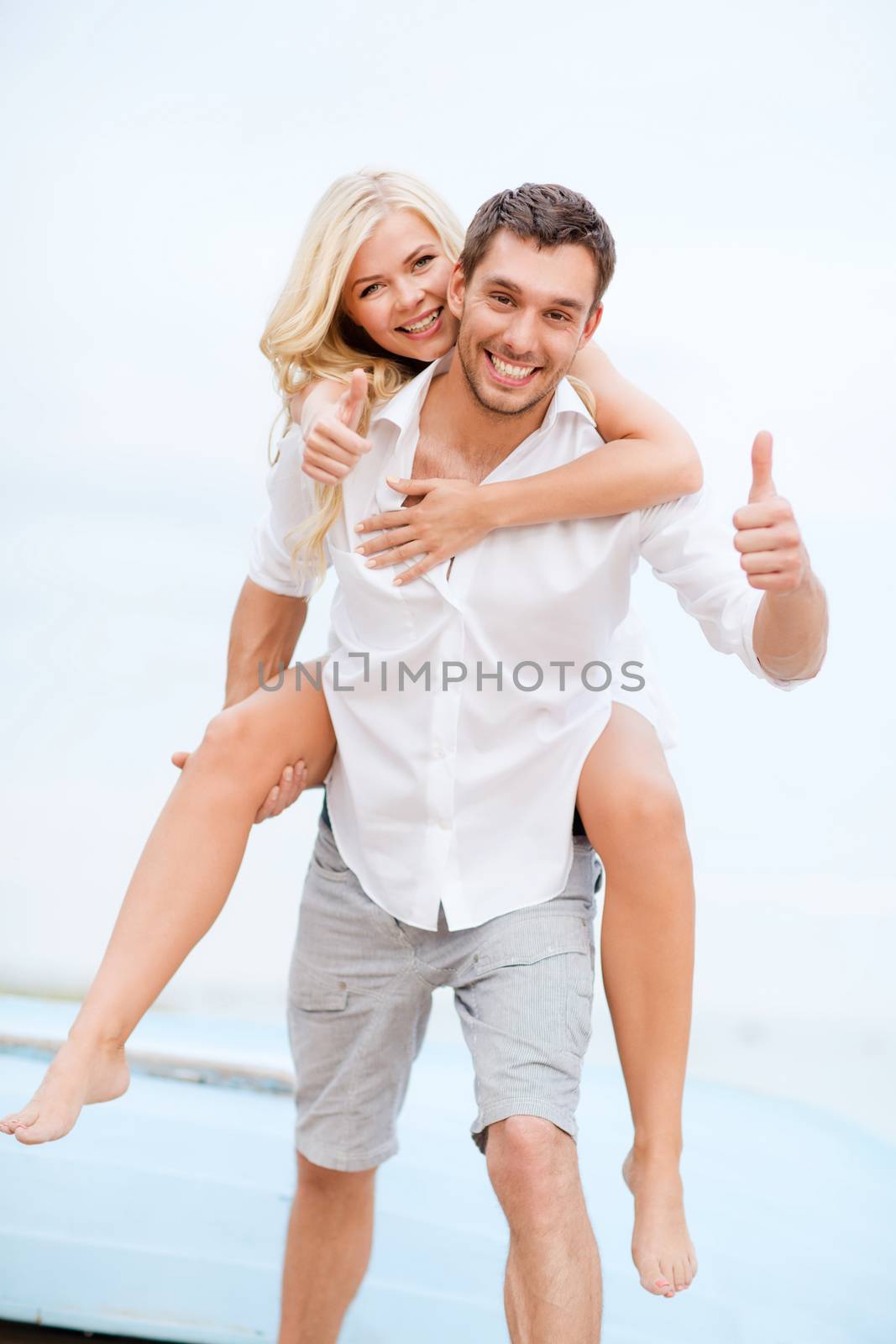 couple having fun on the beach by dolgachov