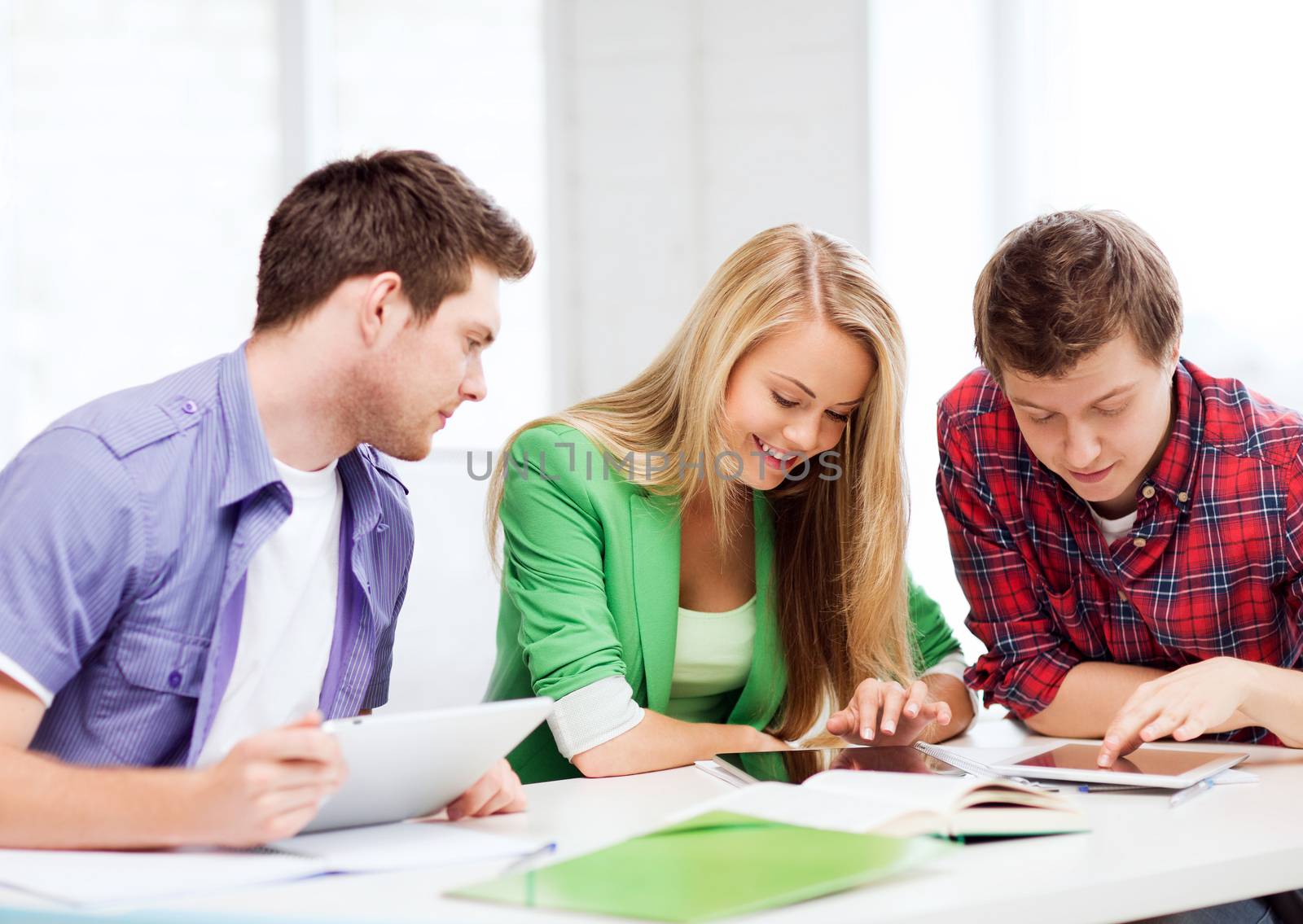 education and internet - smiling students browsing in tablet pc