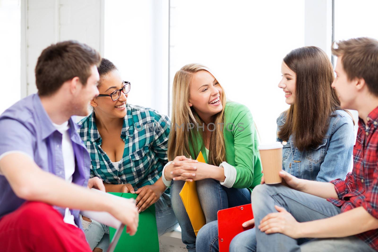 students communicating and laughing at school by dolgachov