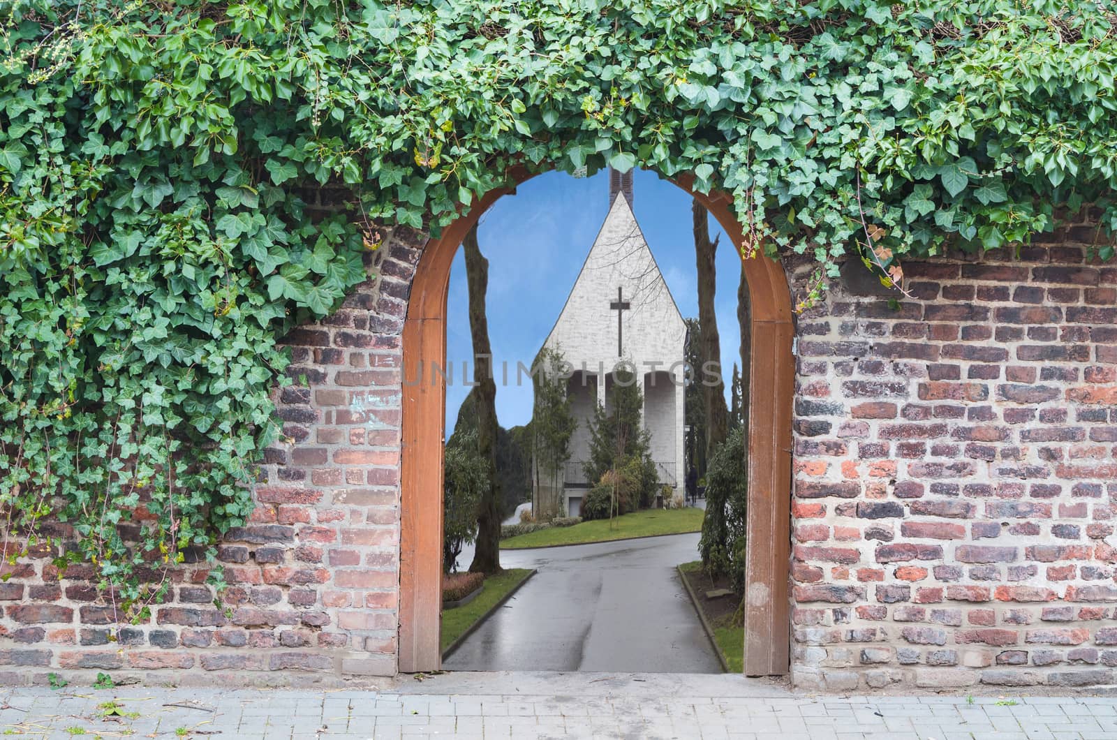 Photomontage, a gate in a wall into a park. Behind the open door you see a road to a small chapel.