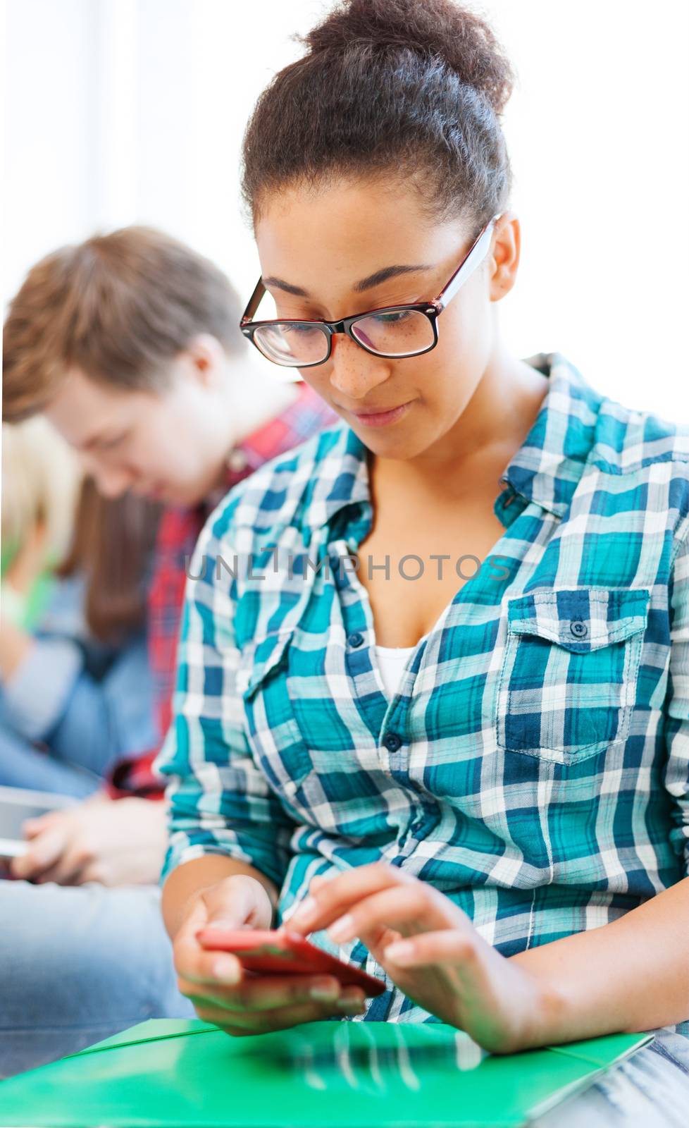 education concept - smiling international student girl with smartphone at school