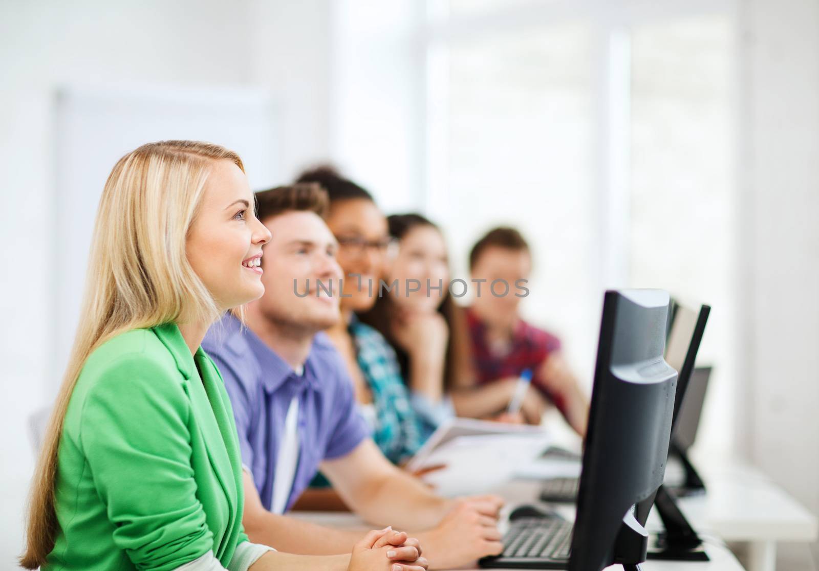 education concept - students with computers studying at school