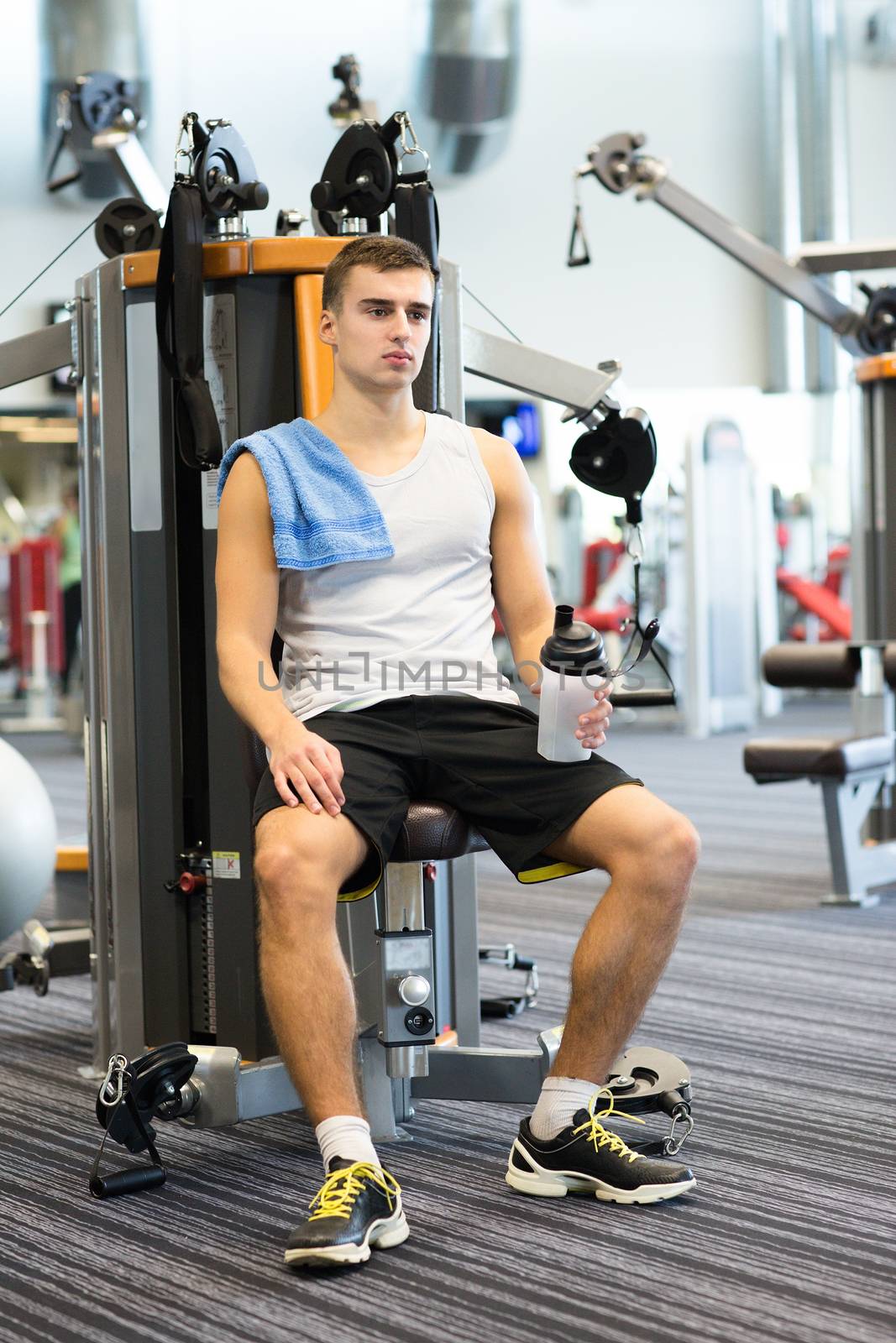 sport, fitness, equipment, lifestyle and people concept - man exercising on gym machine