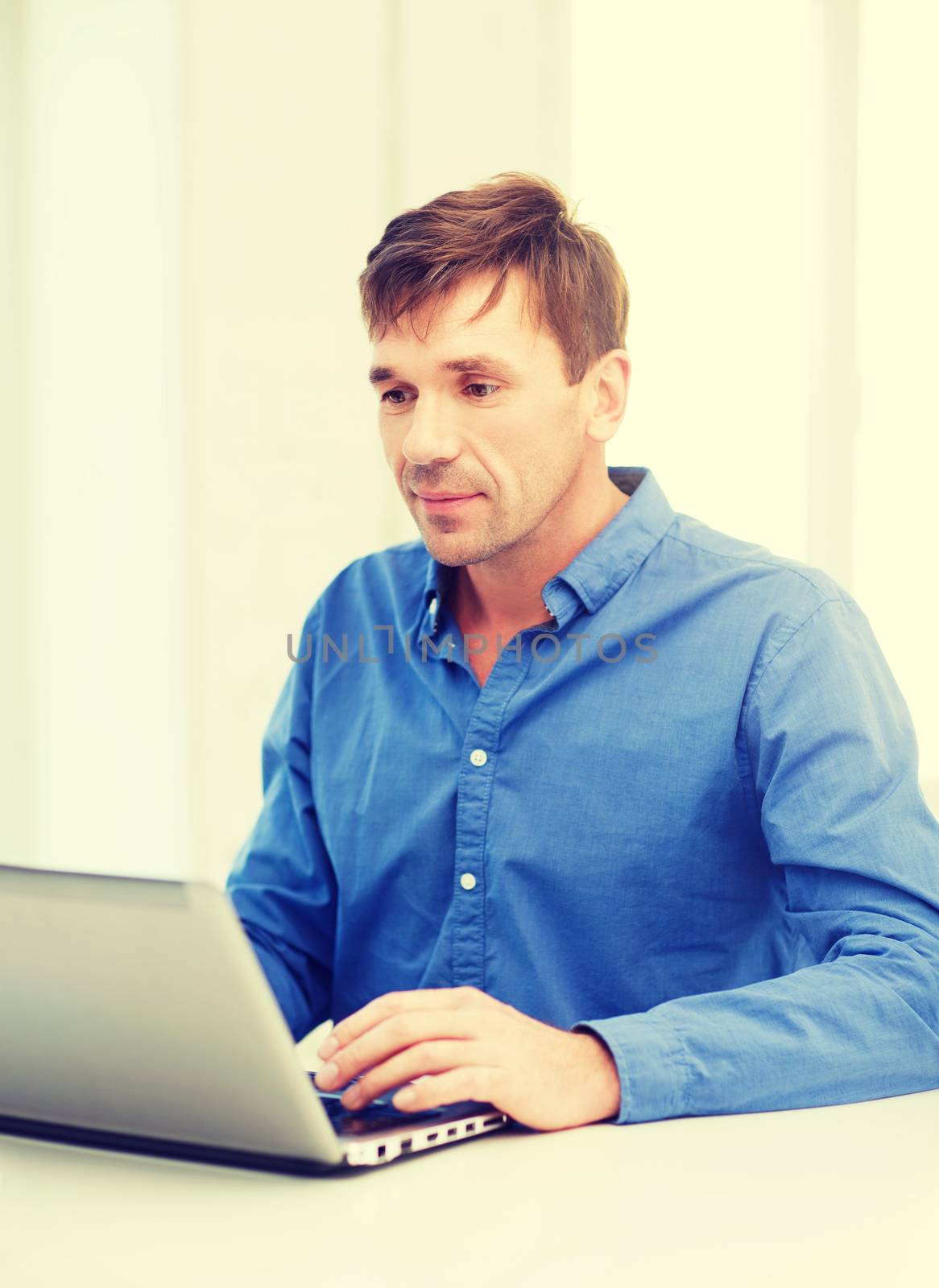 man working with laptop at home by dolgachov