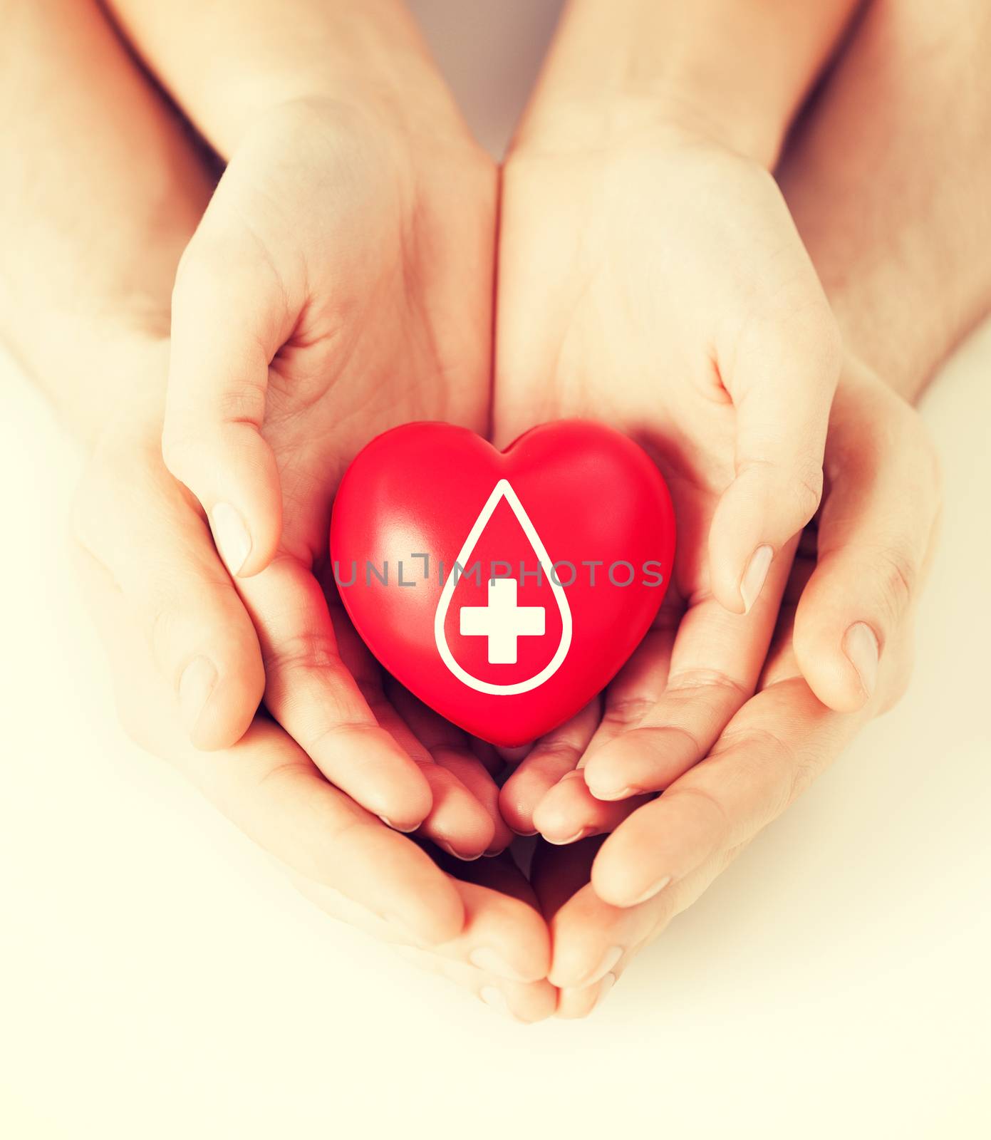 healthcare, medicine and blood donation concept - male and female hands holding red heart with donor sign