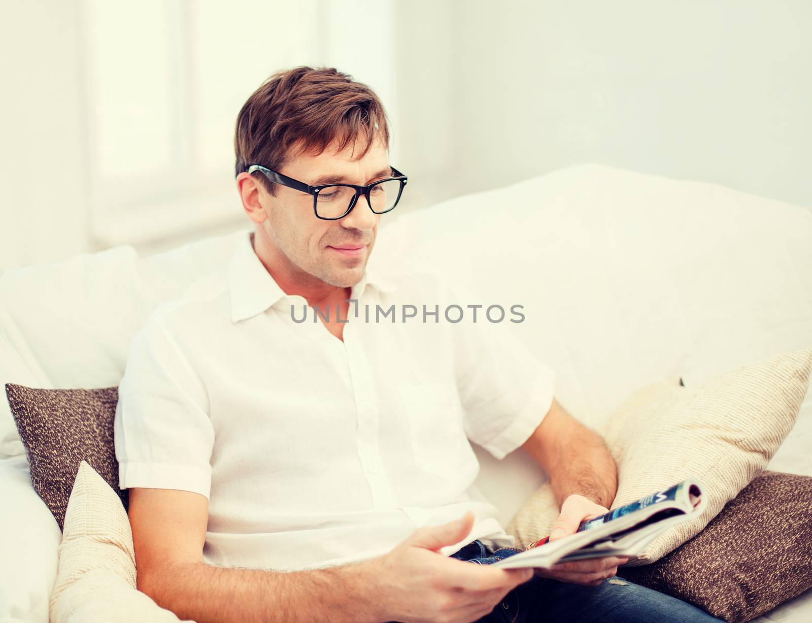 leisure, education and lifestyle concept - man with magazine at home