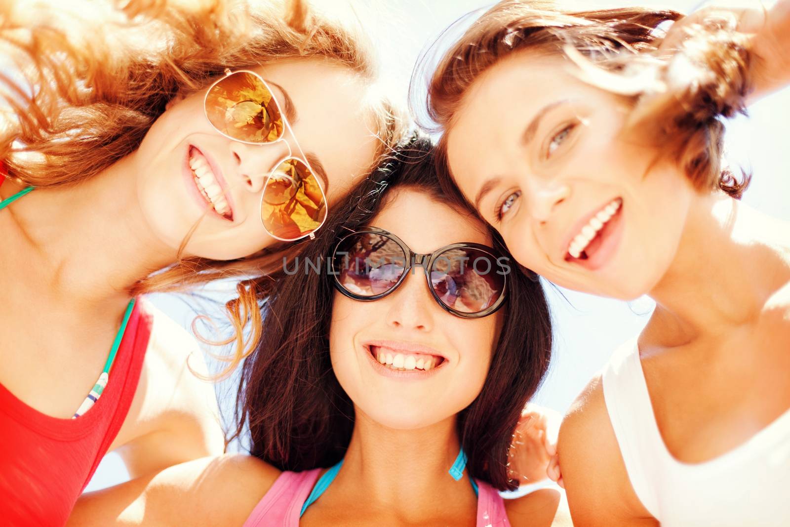 summer holidays and vacation - girls faces with shades looking down