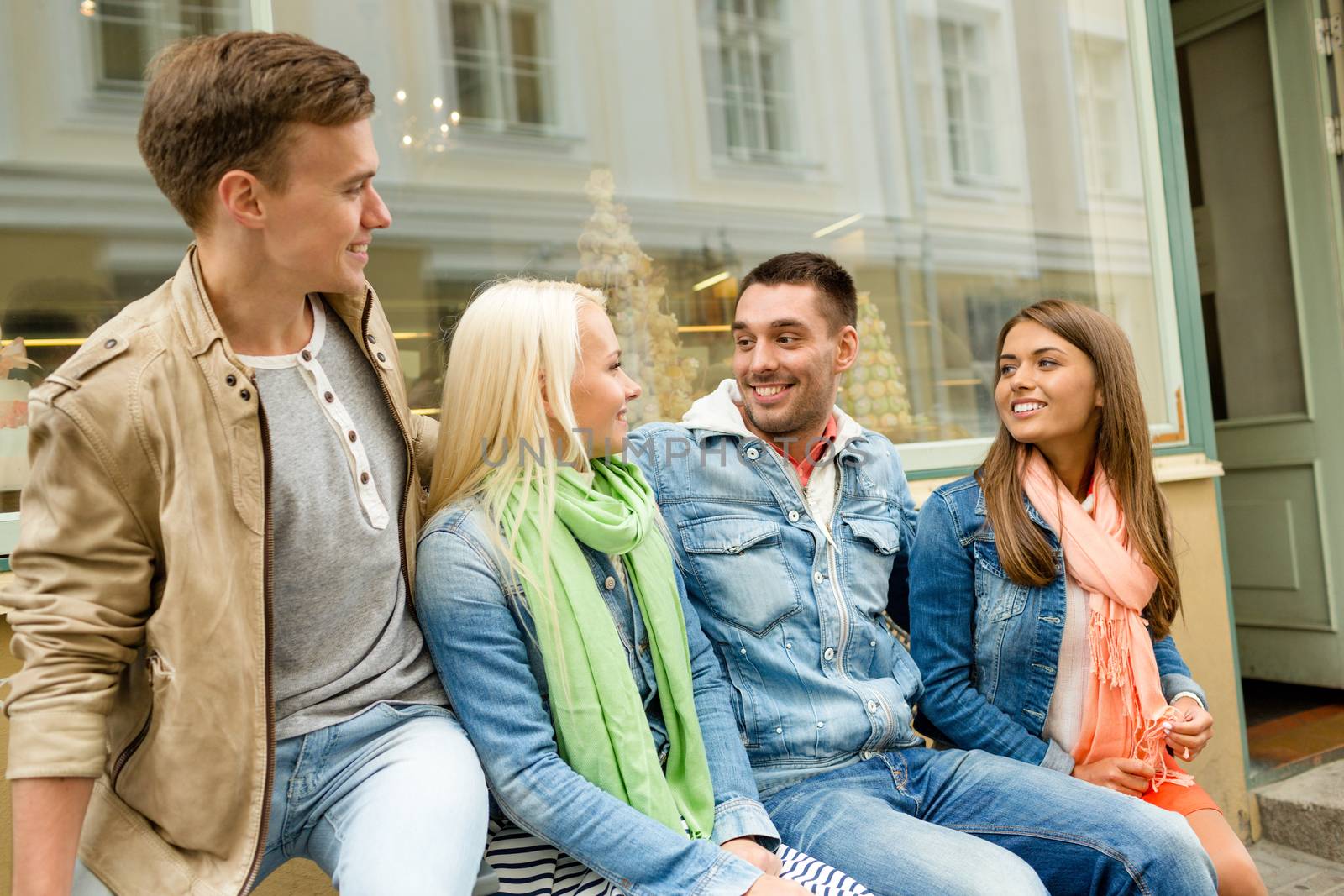 friendship, travel and vacation concept - group of smiling friends in the city