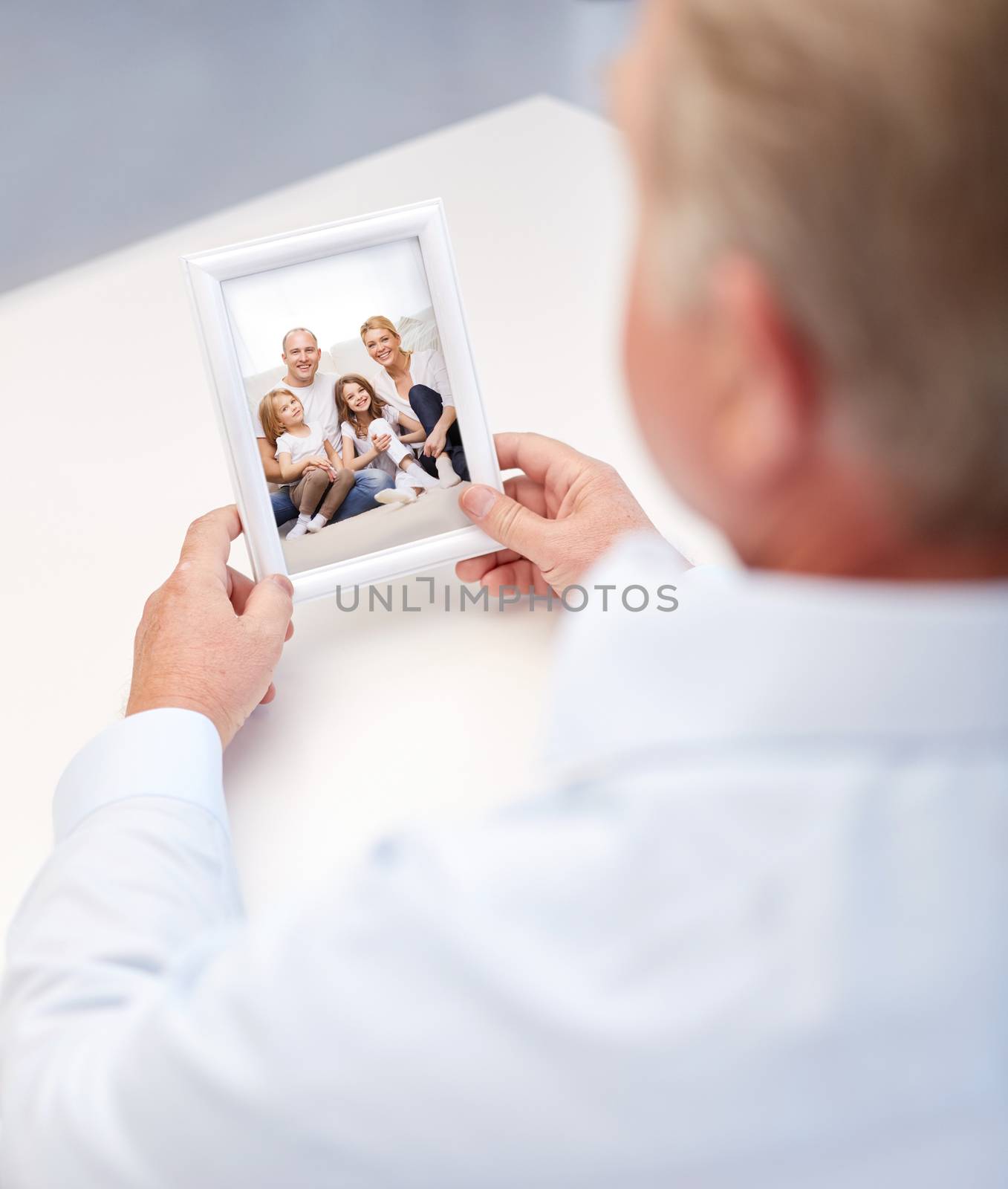 close up of old man holding happy family photo by dolgachov