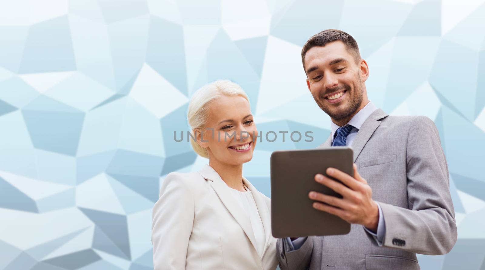 business, partnership, technology and people concept - smiling businessman and businesswoman with tablet pc computer over gray blue graphic low poly background