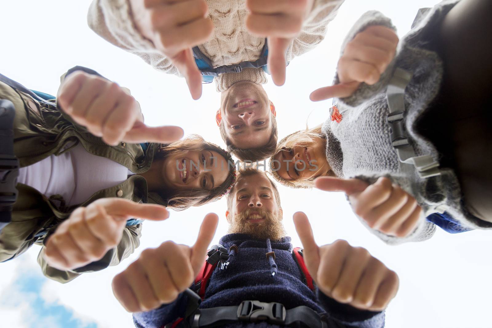 group of smiling friends with backpacks hiking by dolgachov