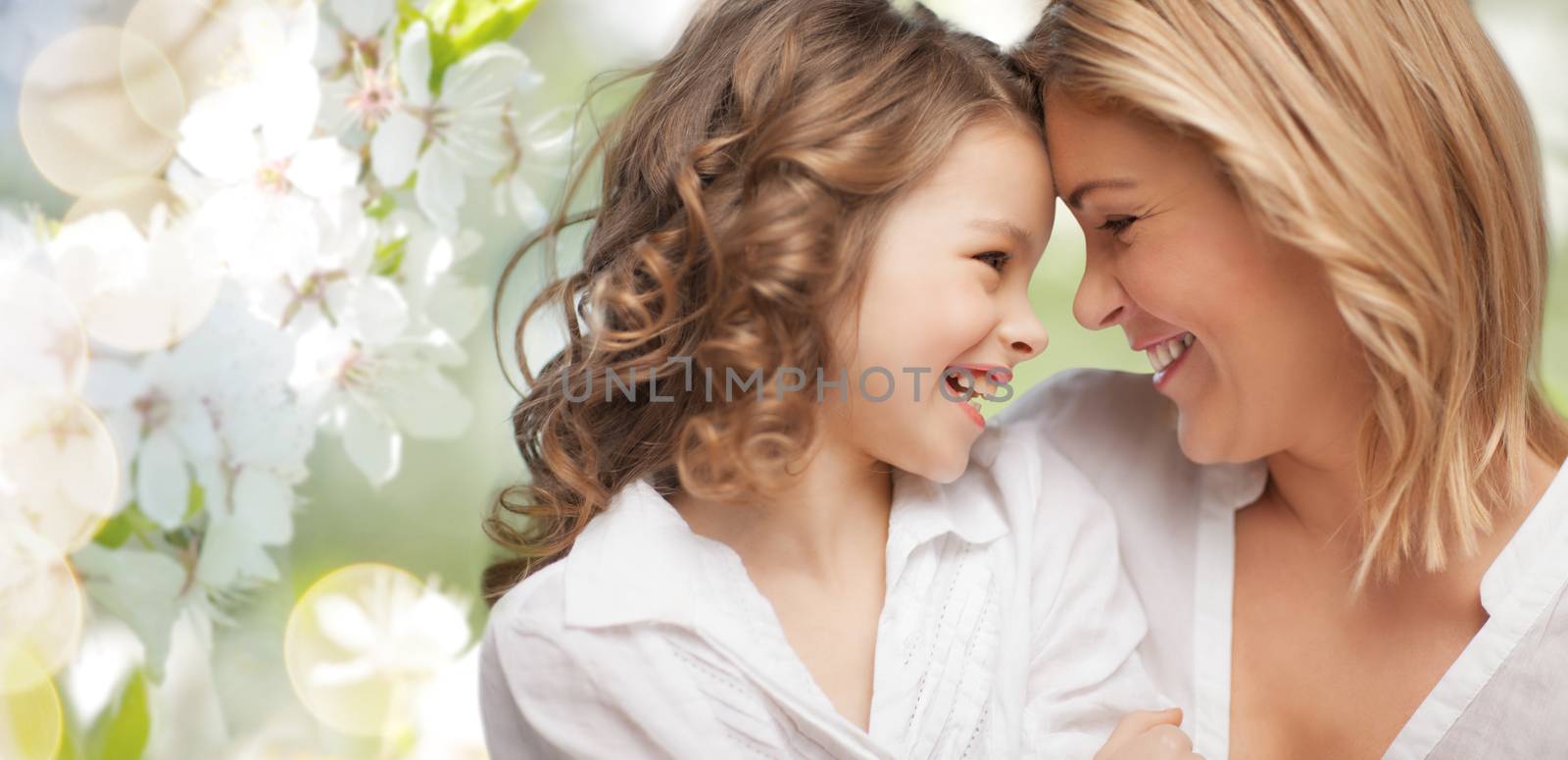 people, family, love and harmony concept - happy mother and daughter cuddling over green summer garden background