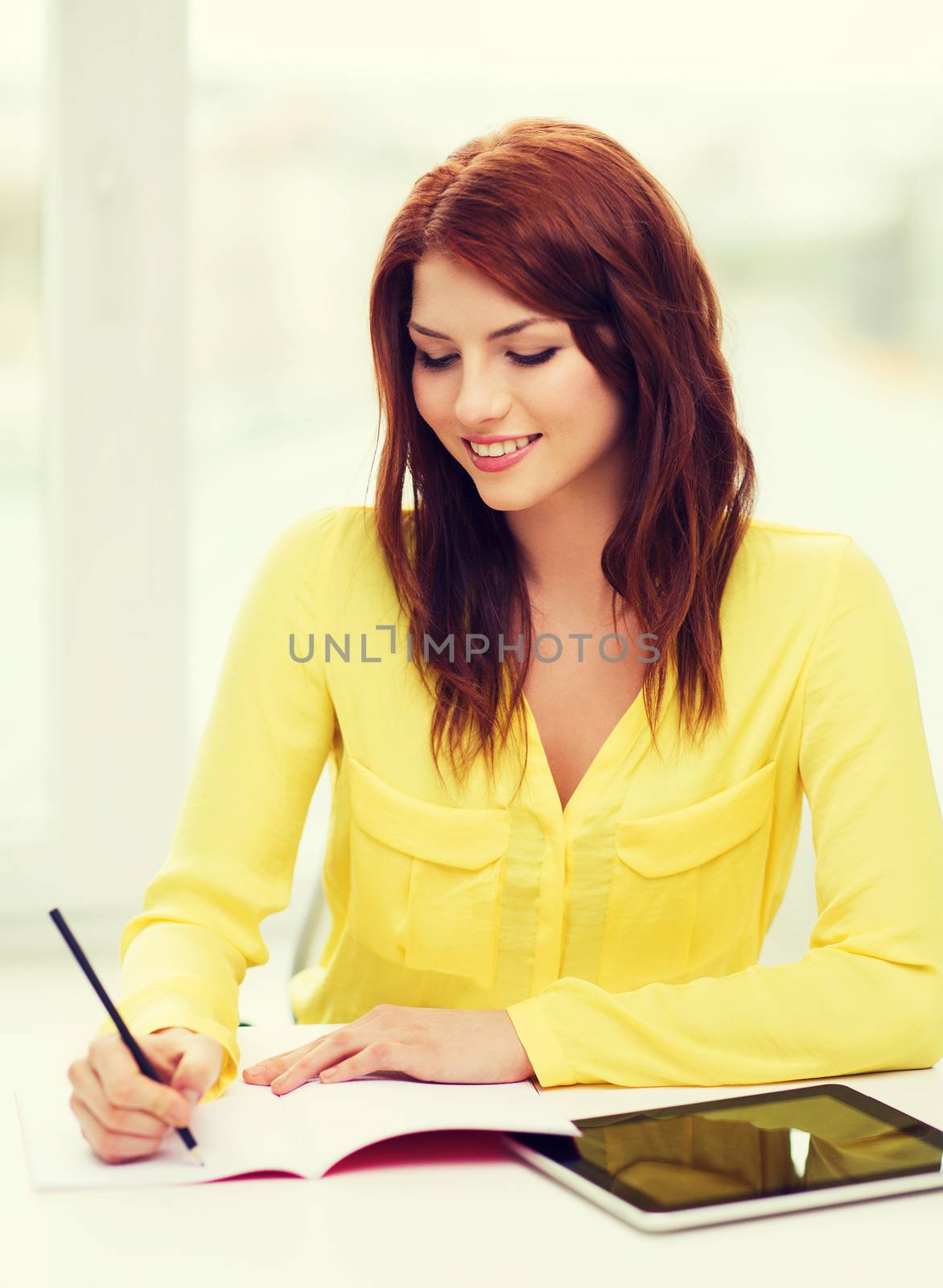 business, education and technology concept - smiling student with tablet pc computer and notebook in college