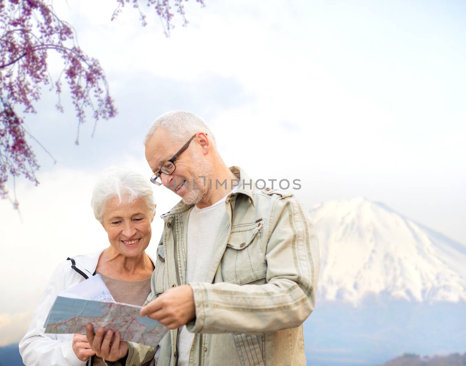 happy senior couple with travel map over mountains by dolgachov