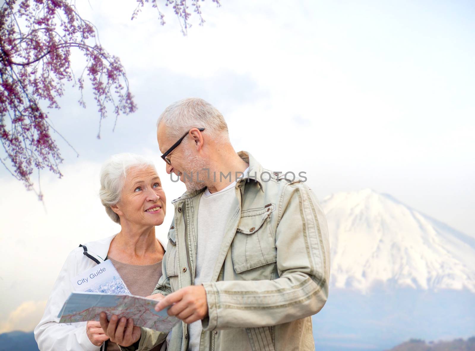 happy senior couple with travel map over mountains by dolgachov