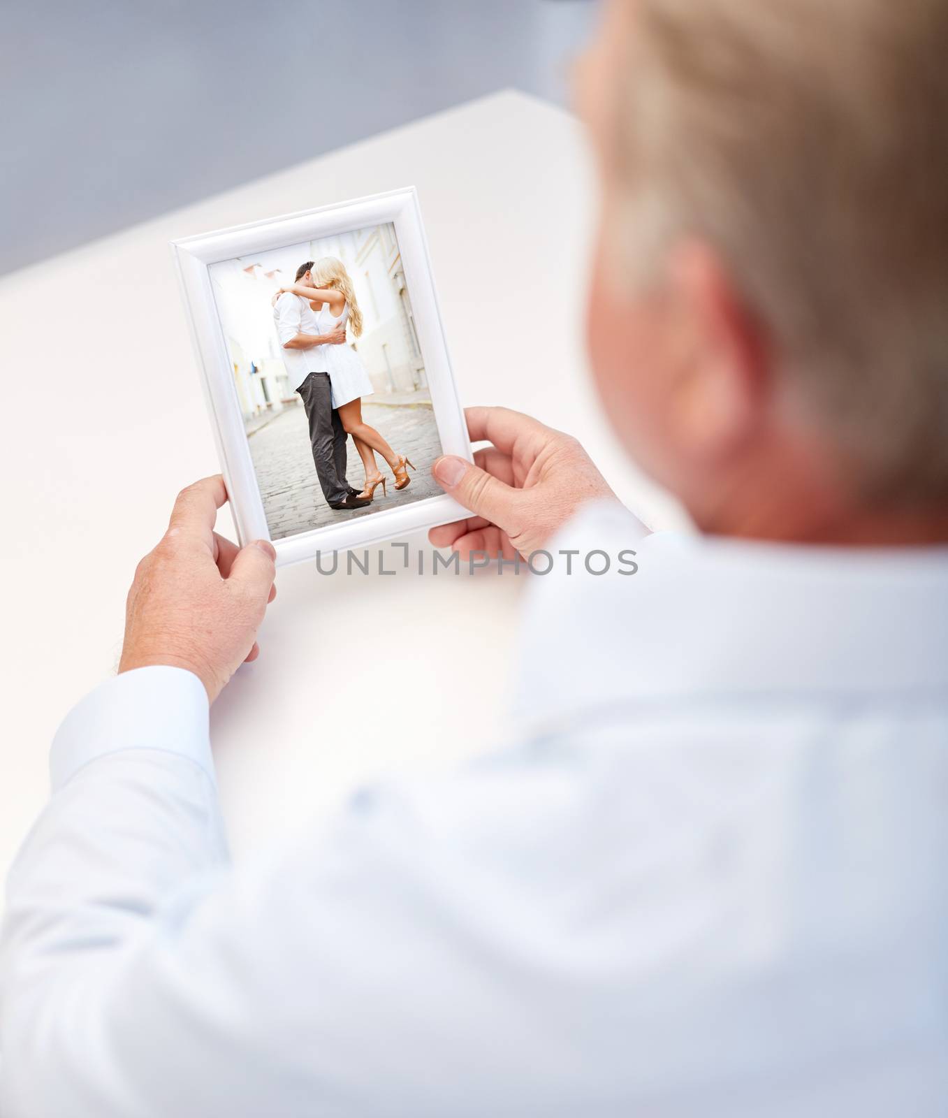 oldness, memories, nostalgia and people concept - close up of old man holding and looking at happy young couple photo