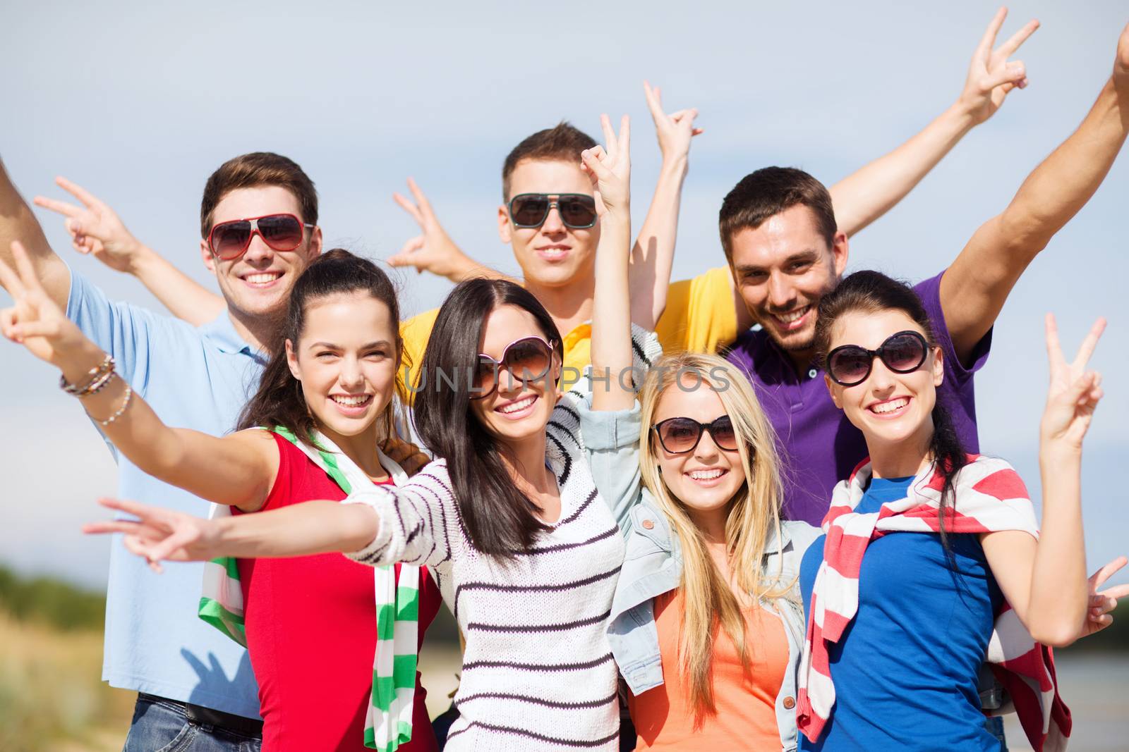 group of happy friends having fun on beach by dolgachov