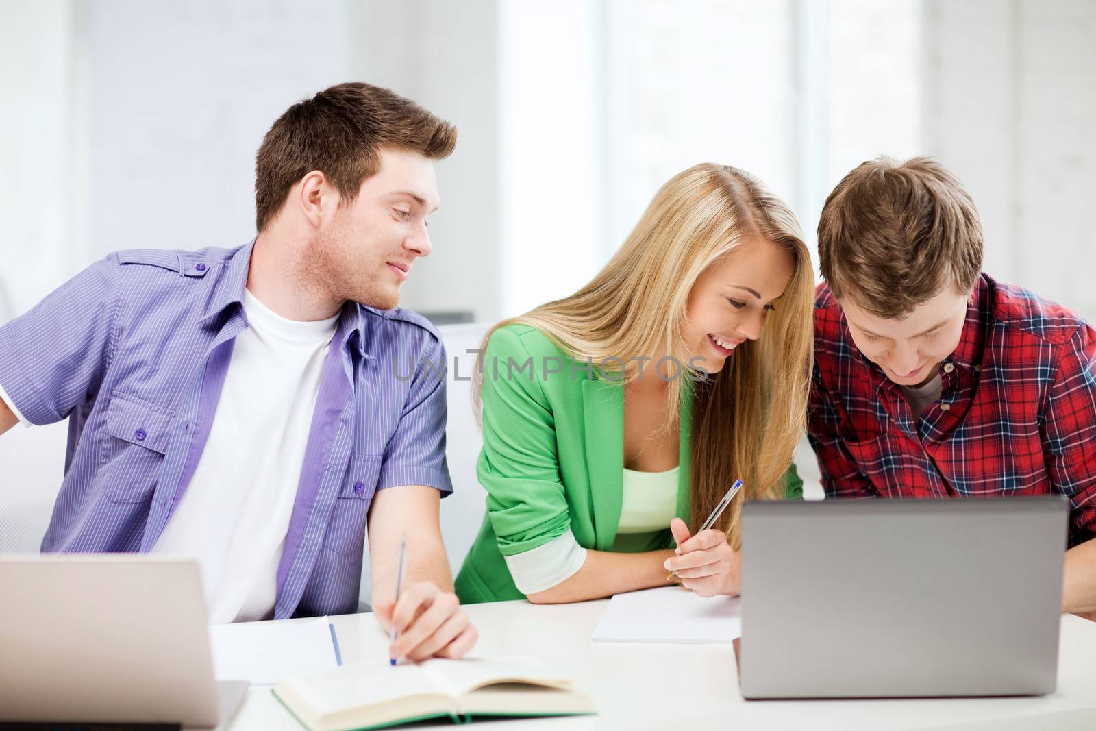 students writing something at school by dolgachov