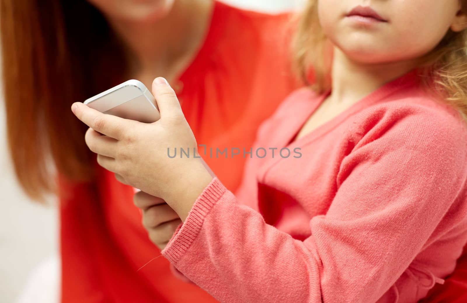 close up of woman and little girl with smartphone by dolgachov