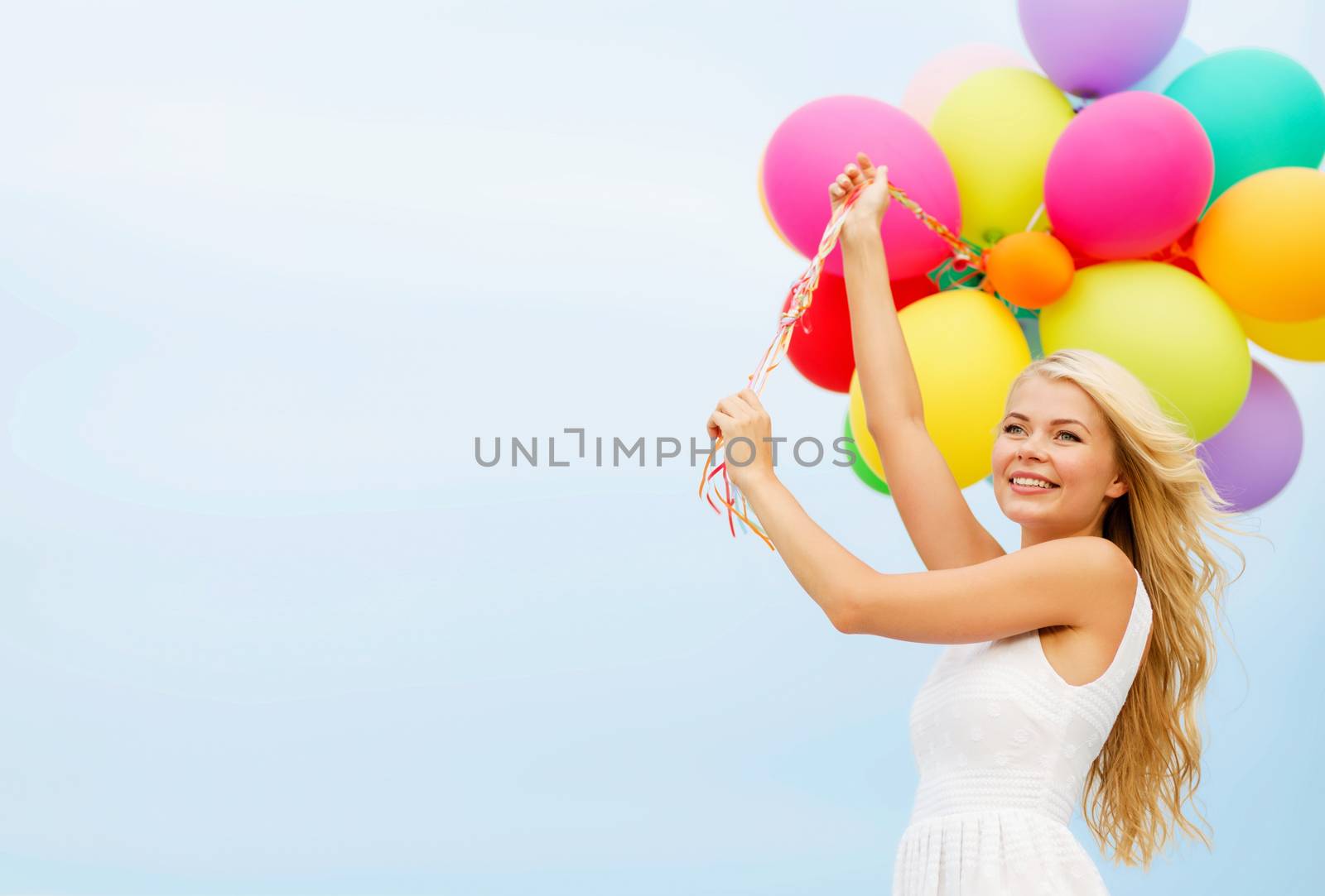 smiling woman with colorful balloons outside by dolgachov