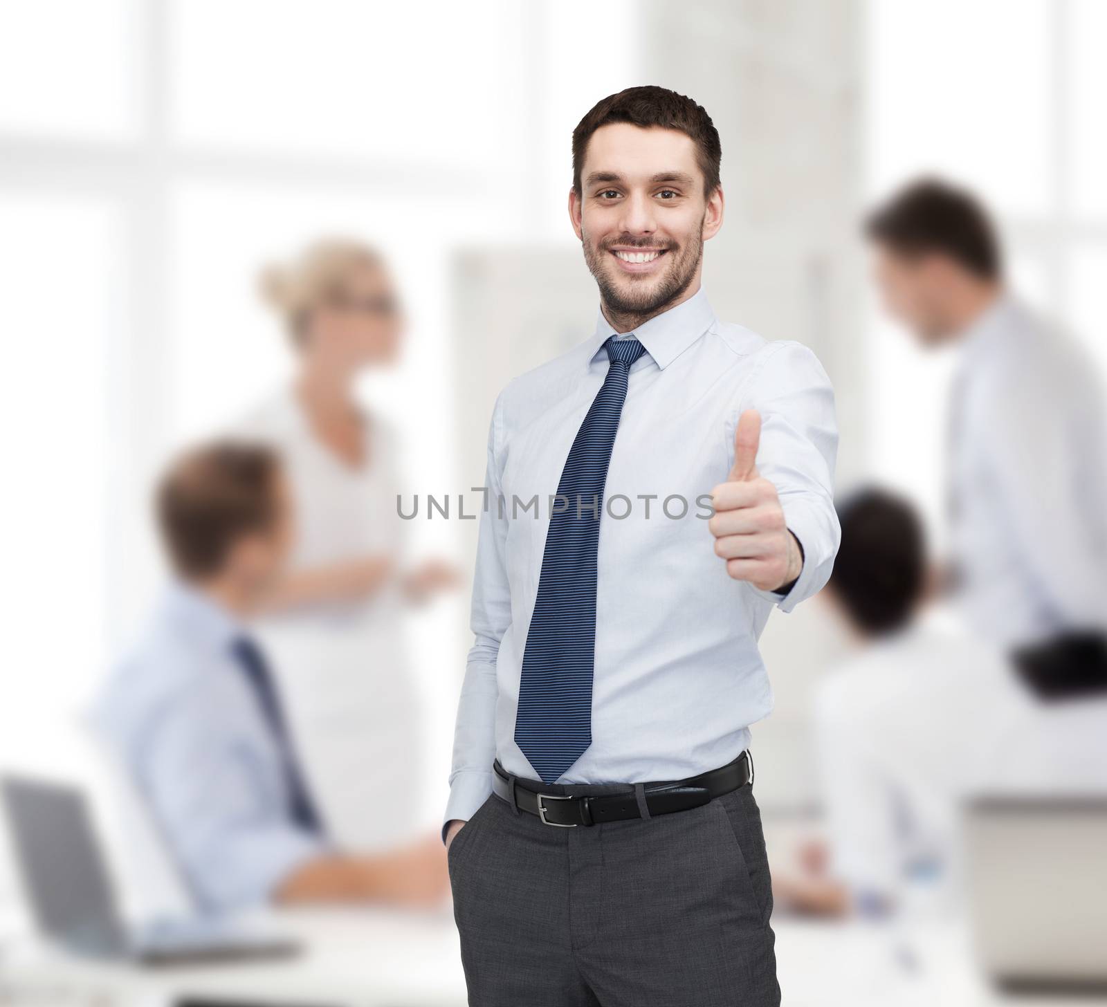 business and office concept - handsome businessman showing thumbs up