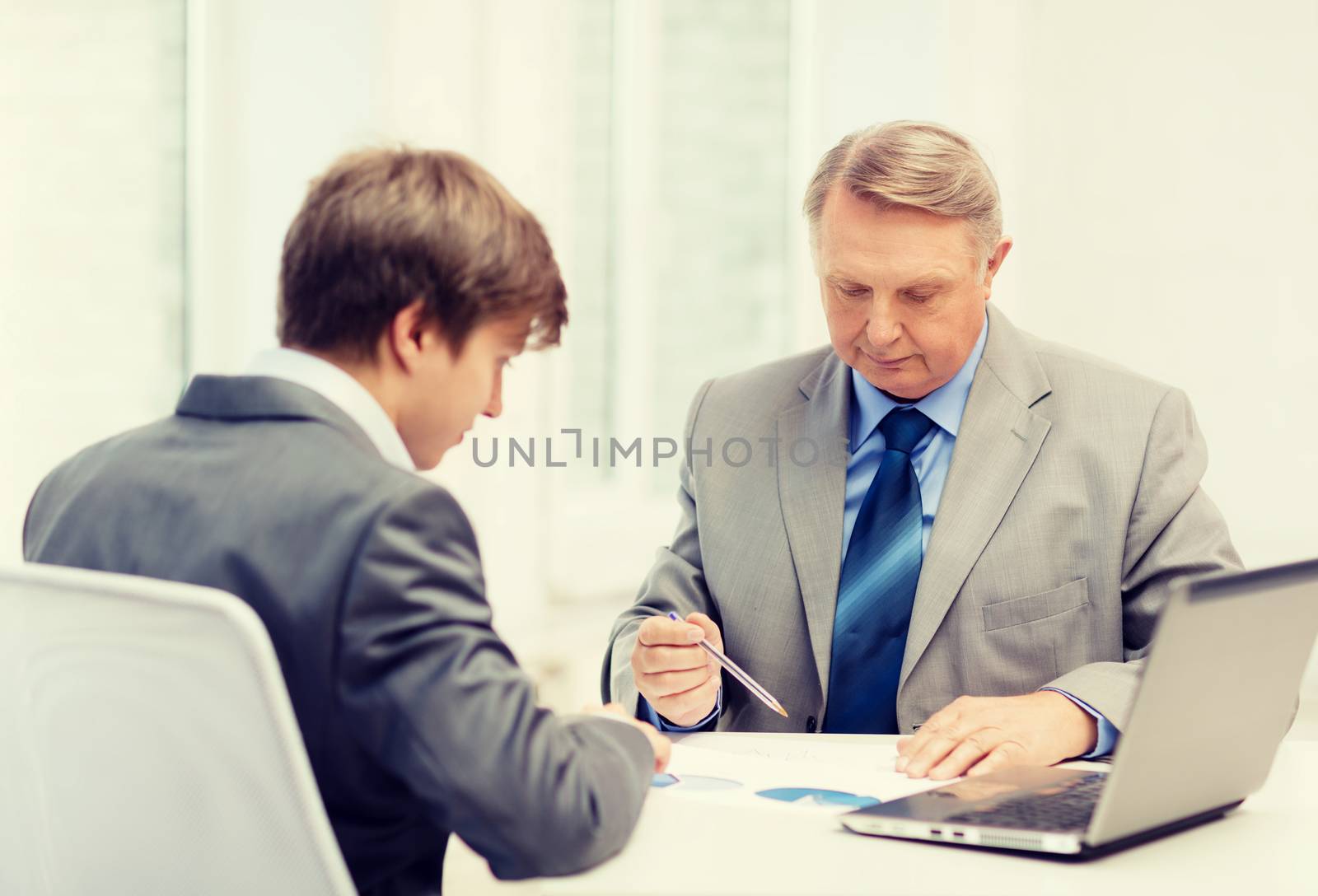 older man and young man having meeting in office by dolgachov