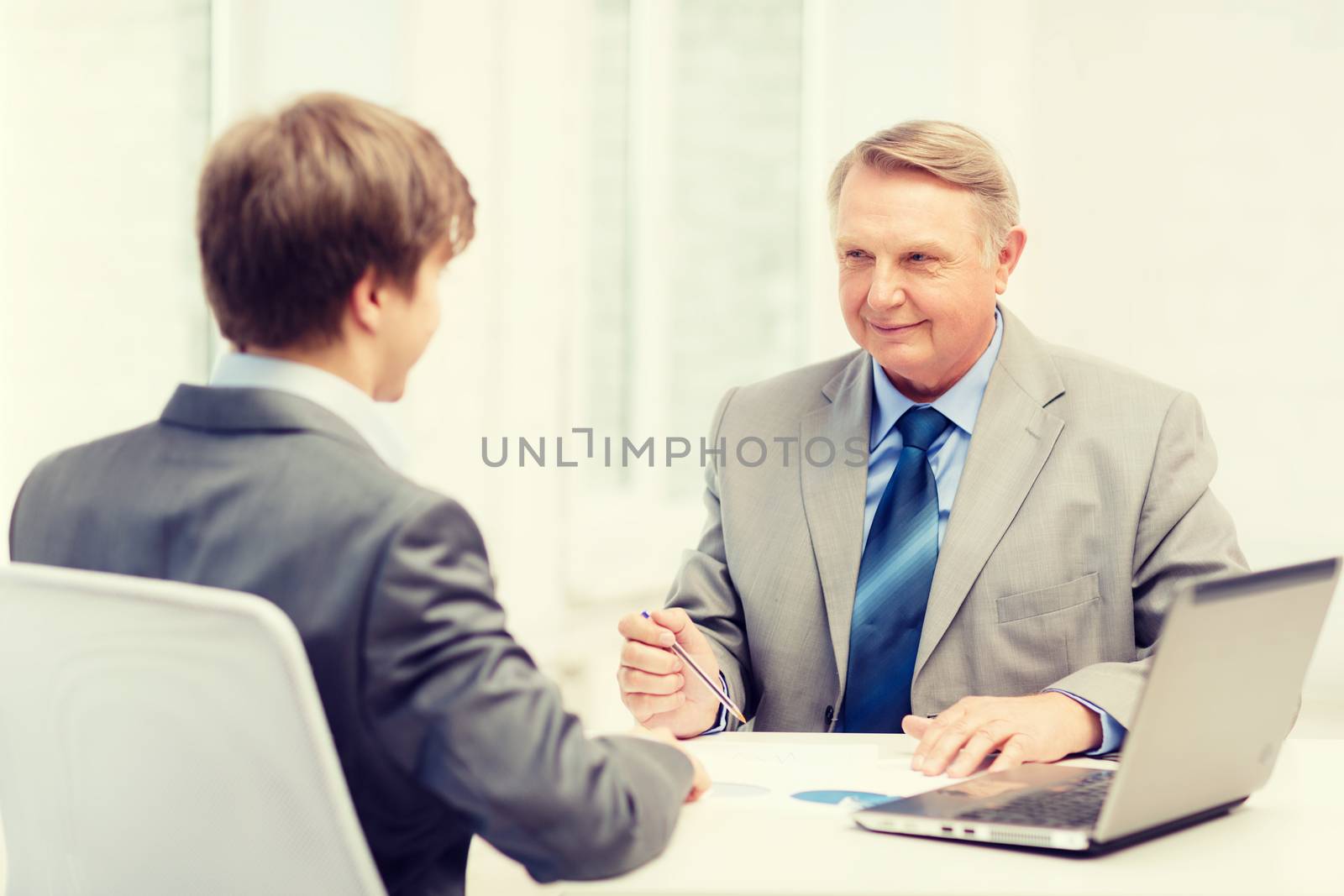 older man and young man having meeting in office by dolgachov