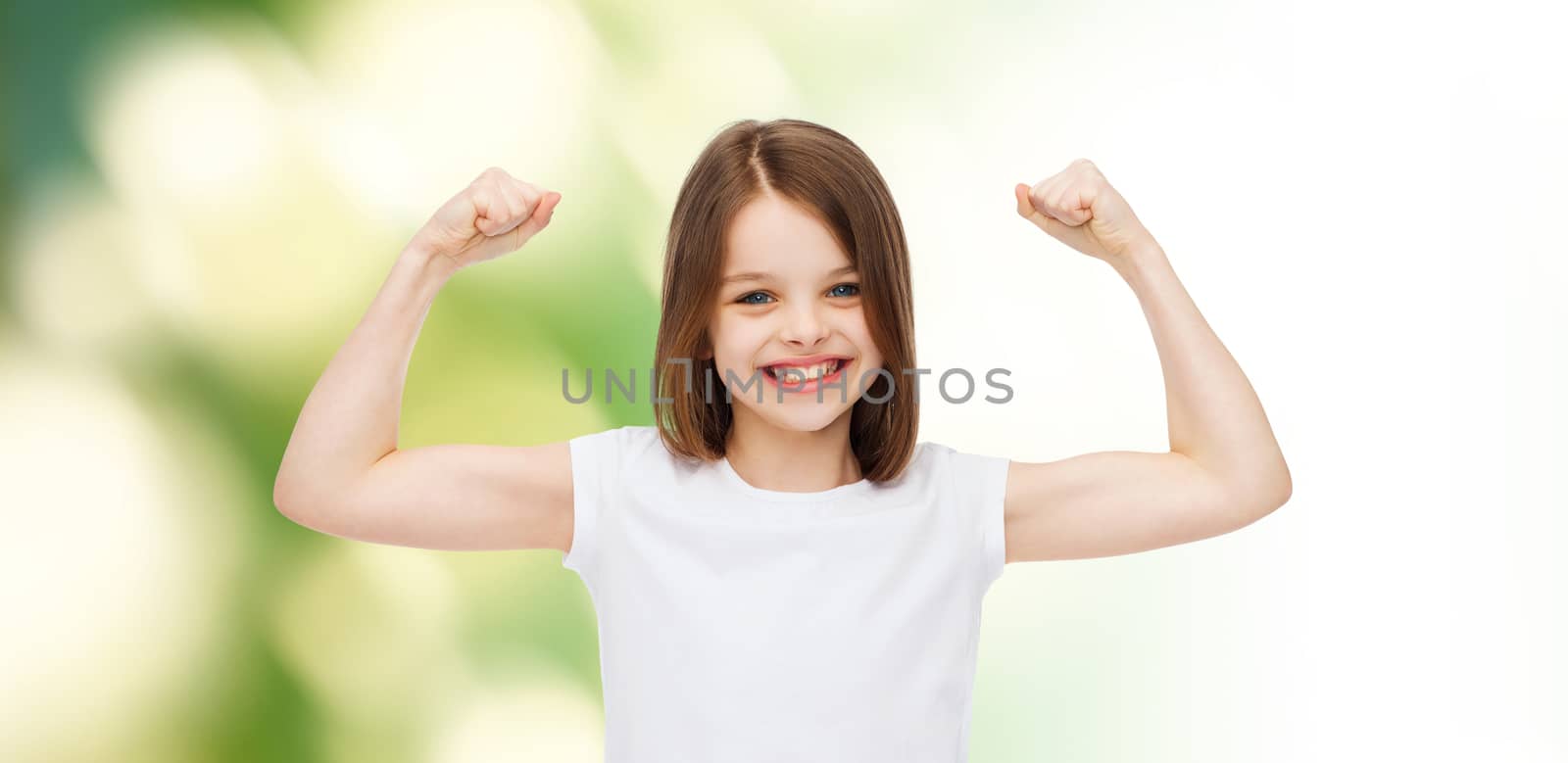 advertising, childhood, gesture, ecology and people - smiling little girl in white blank t-shirt with raised arms over green background