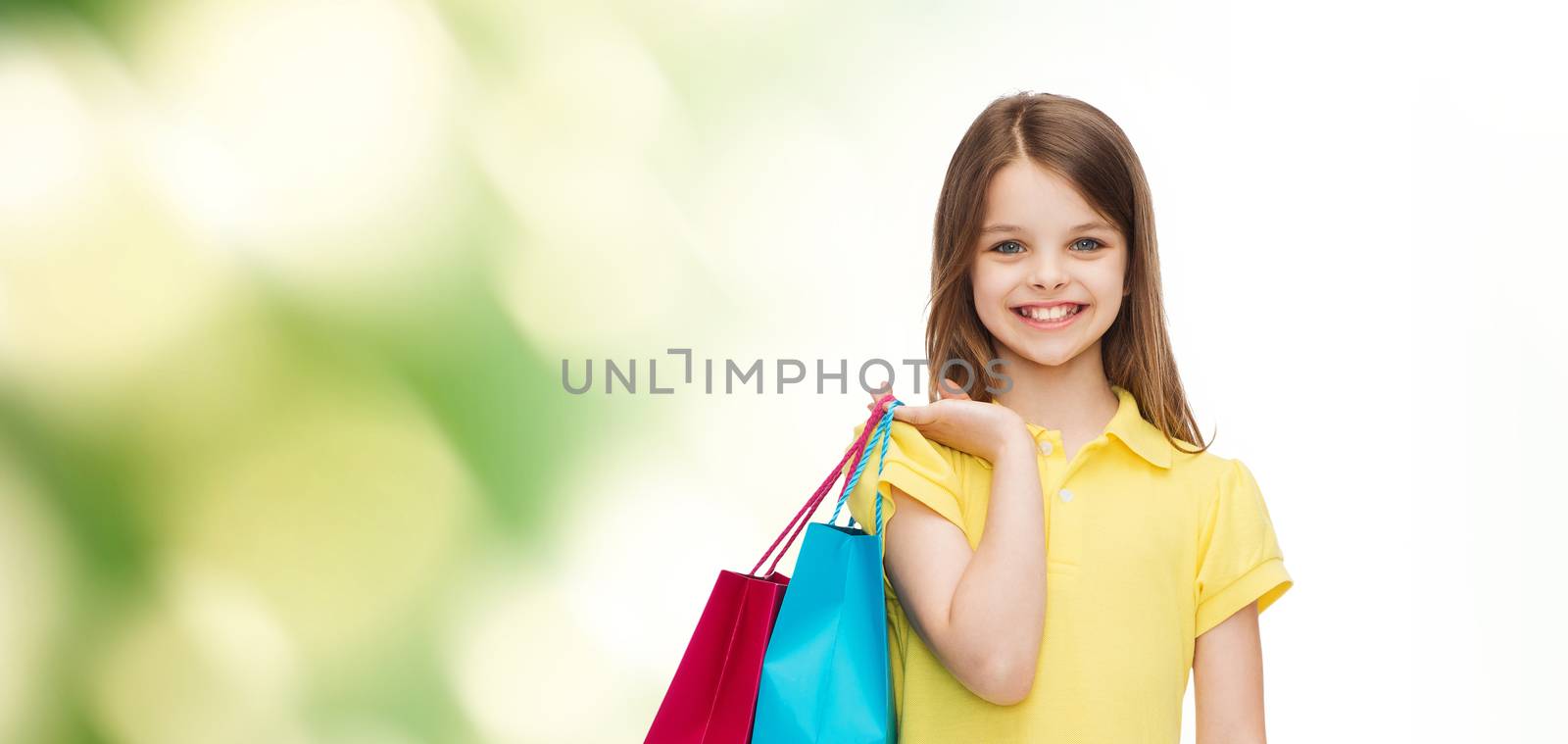 smiling little girl in dress with shopping bags by dolgachov