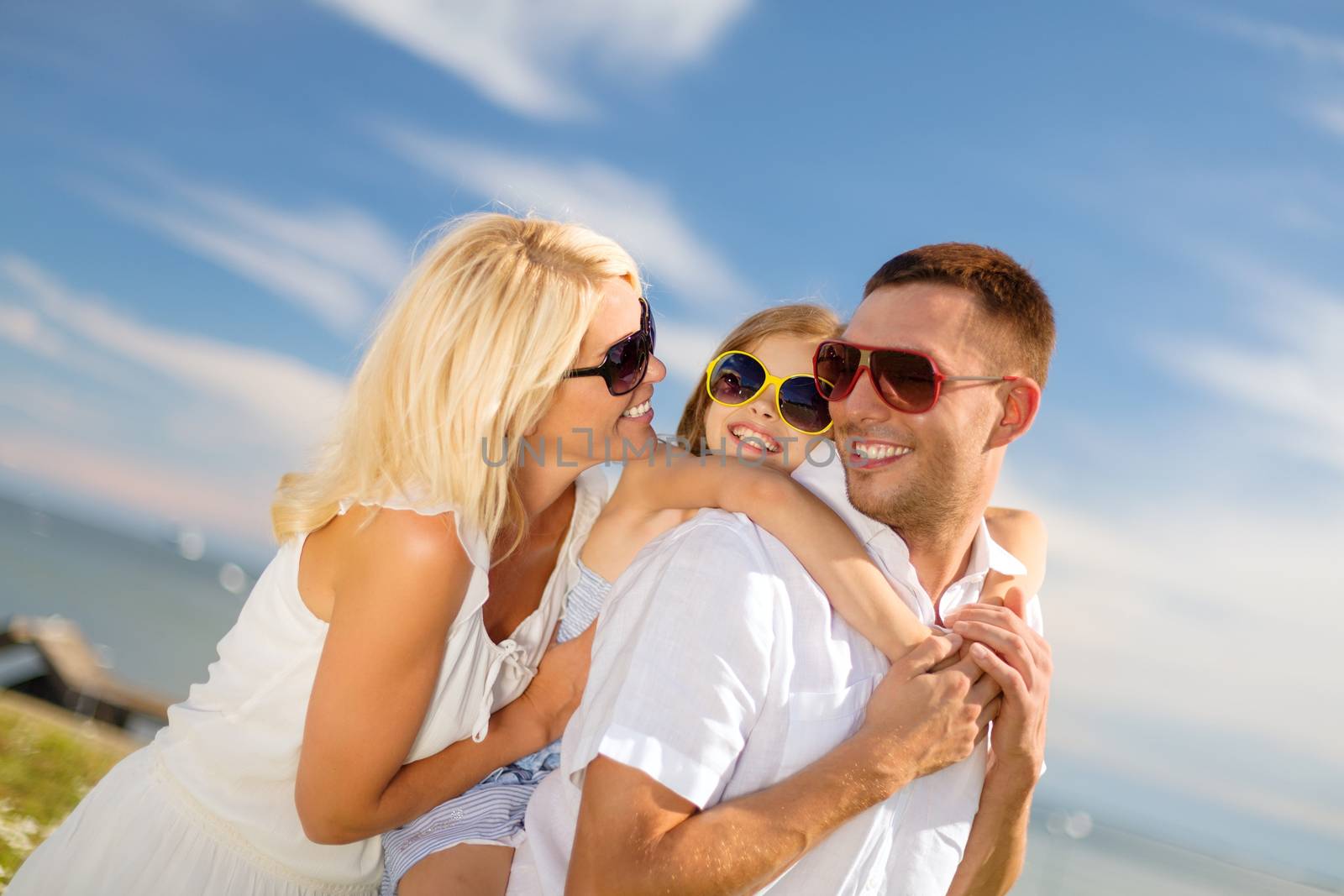 happy family in sunglasses having fun outdoors by dolgachov