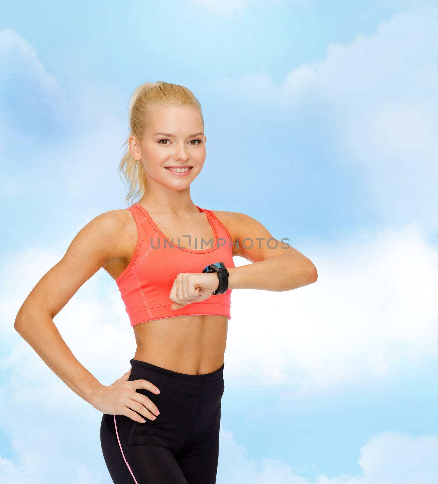 smiling woman with heart rate monitor on hand by dolgachov