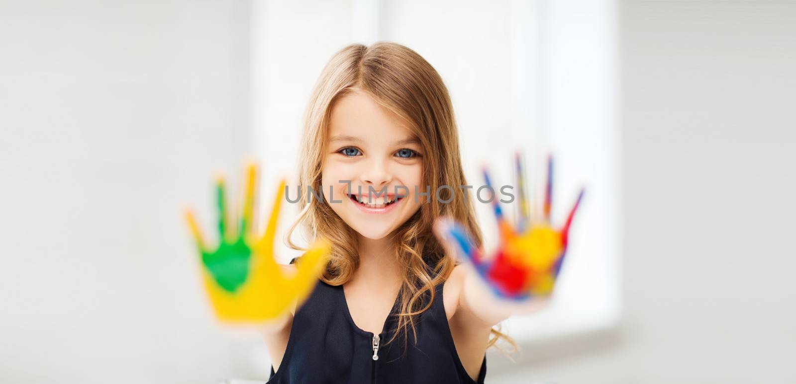 smiling girl showing painted hands by dolgachov