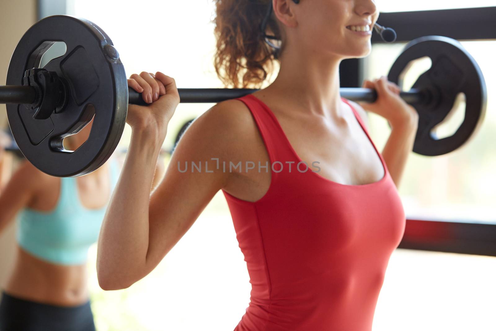 fitness, sport, training, people and lifestyle concept - group of women with barbells flexing muscles in gym