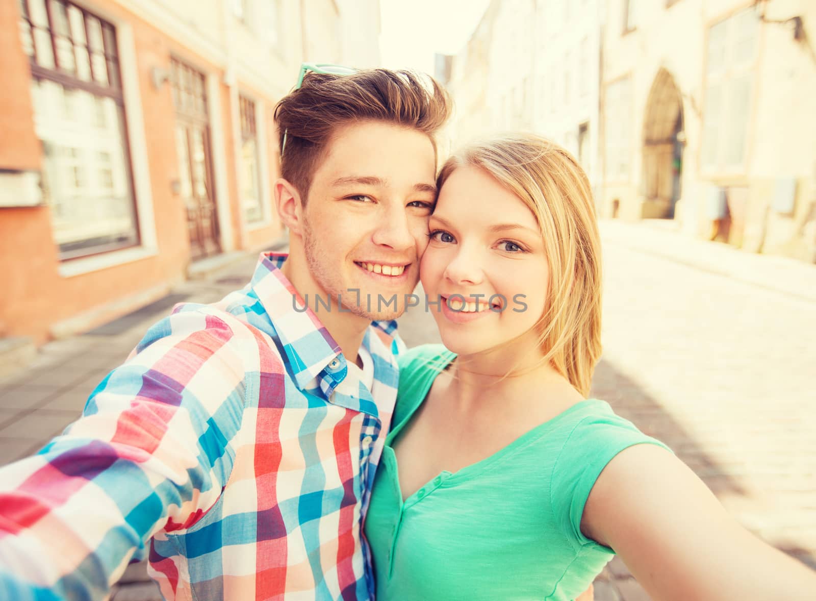 travel, vacation, technology and friendship concept - smiling couple with smartphone in city