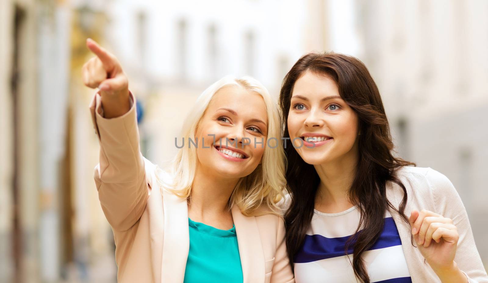 shopping and tourism concept - beautiful girls with shopping bags in ctiy