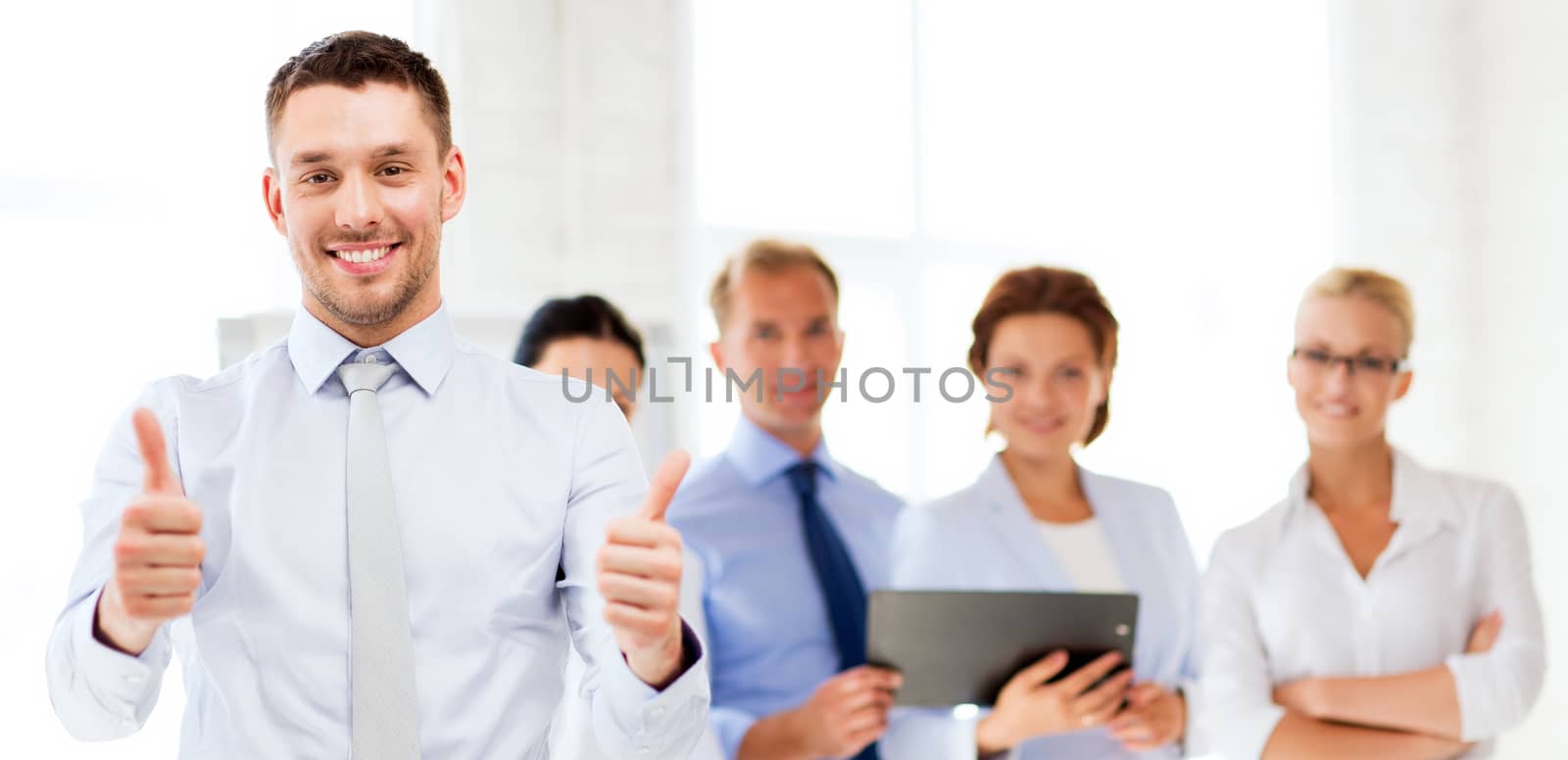 attractive businessman in office showign thumbs up