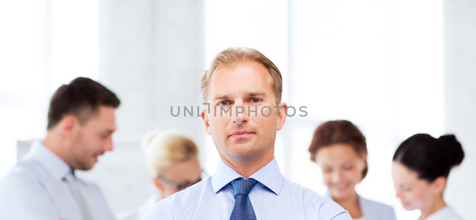 handsome businessman with team in office by dolgachov