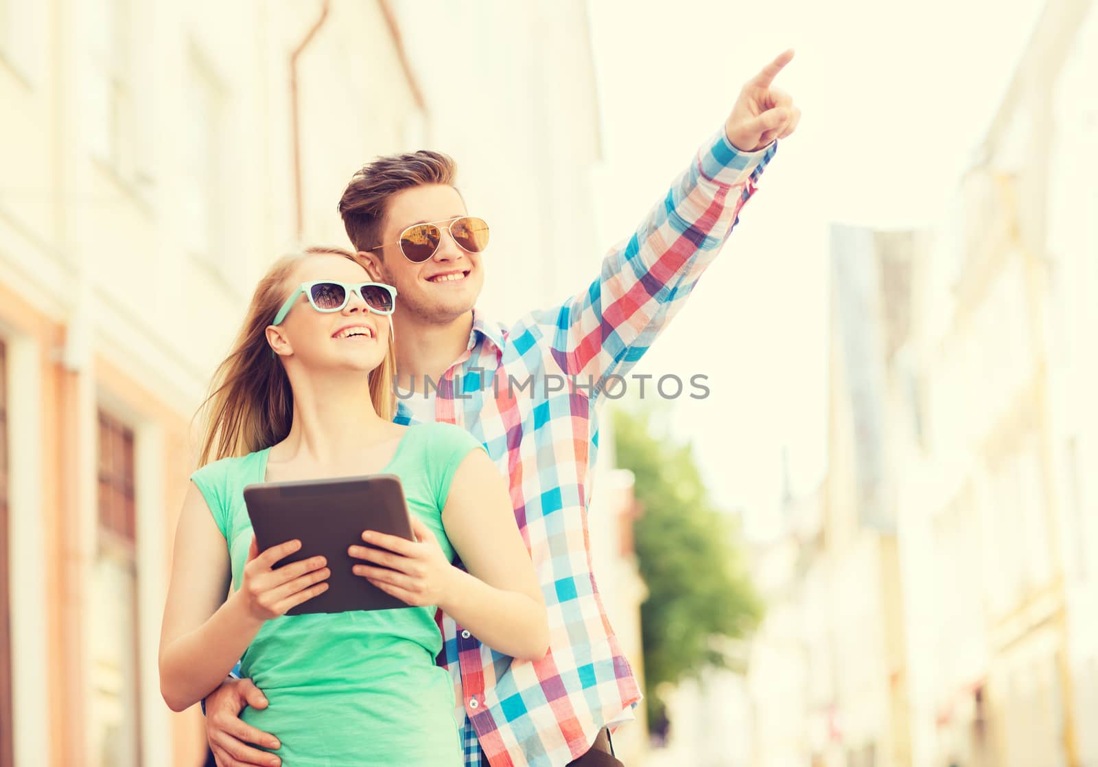 travel, vacation, technology and friendship concept - smiling couple with tablet pc computer in city