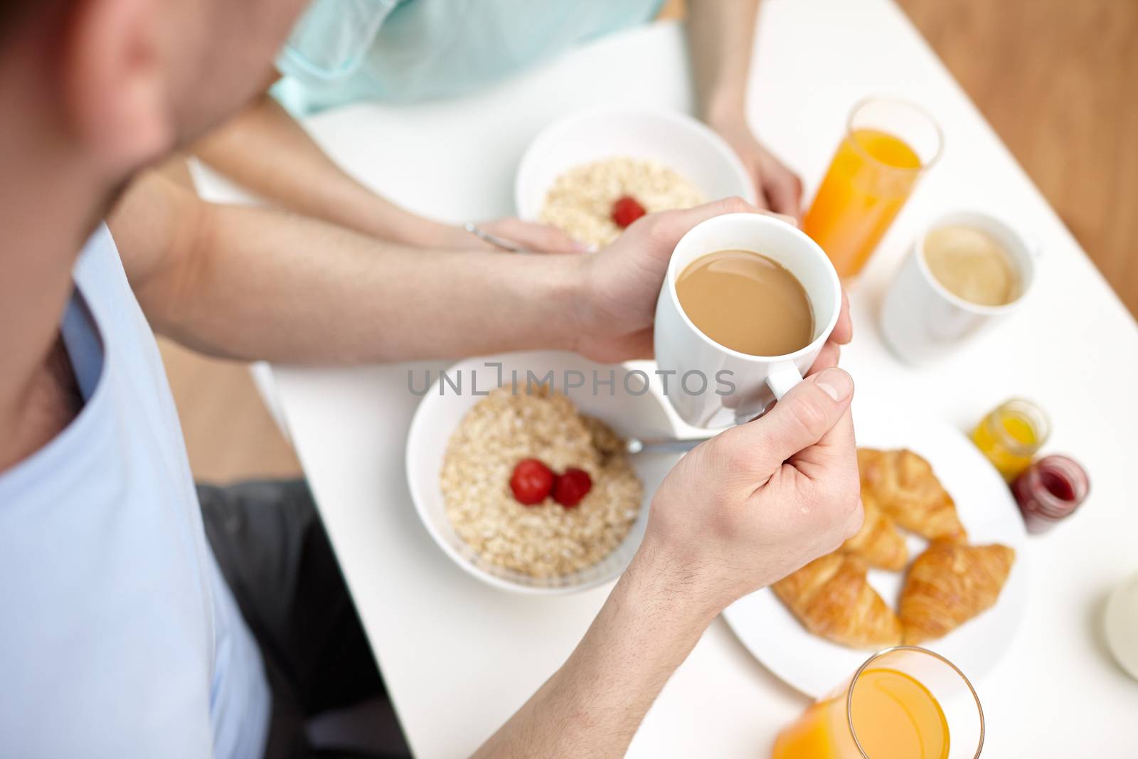 food, eating, people and healthy food concept - close up of couple having breakfast at home