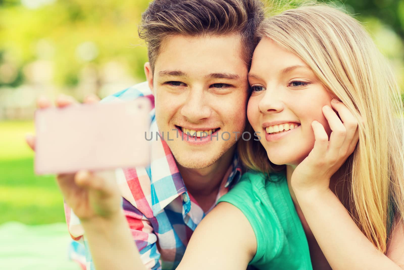 smiling couple making selfie in park by dolgachov