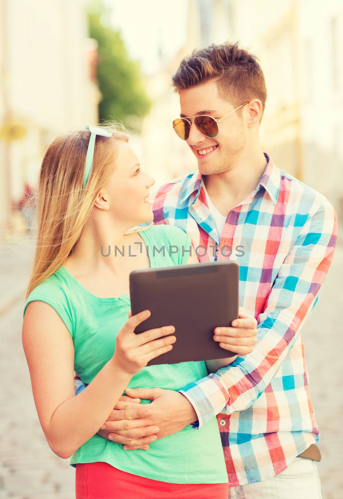 smiling couple with tablet pc in city by dolgachov