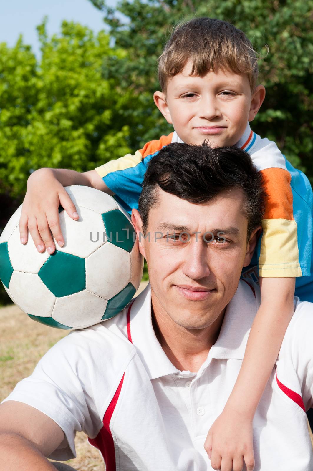 Father and son came to the park to play football and take a picture