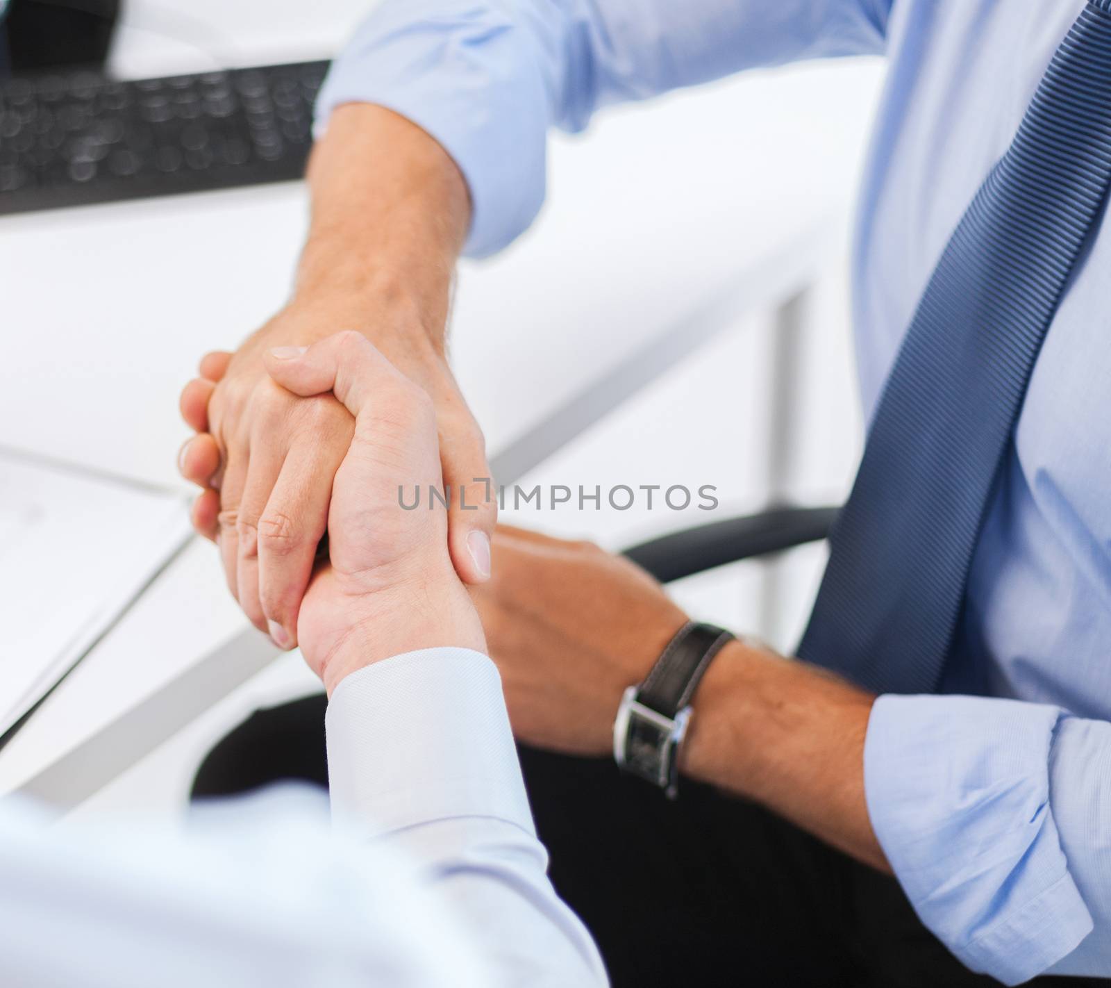 businesss and office concept - two businessmen shaking hands in office