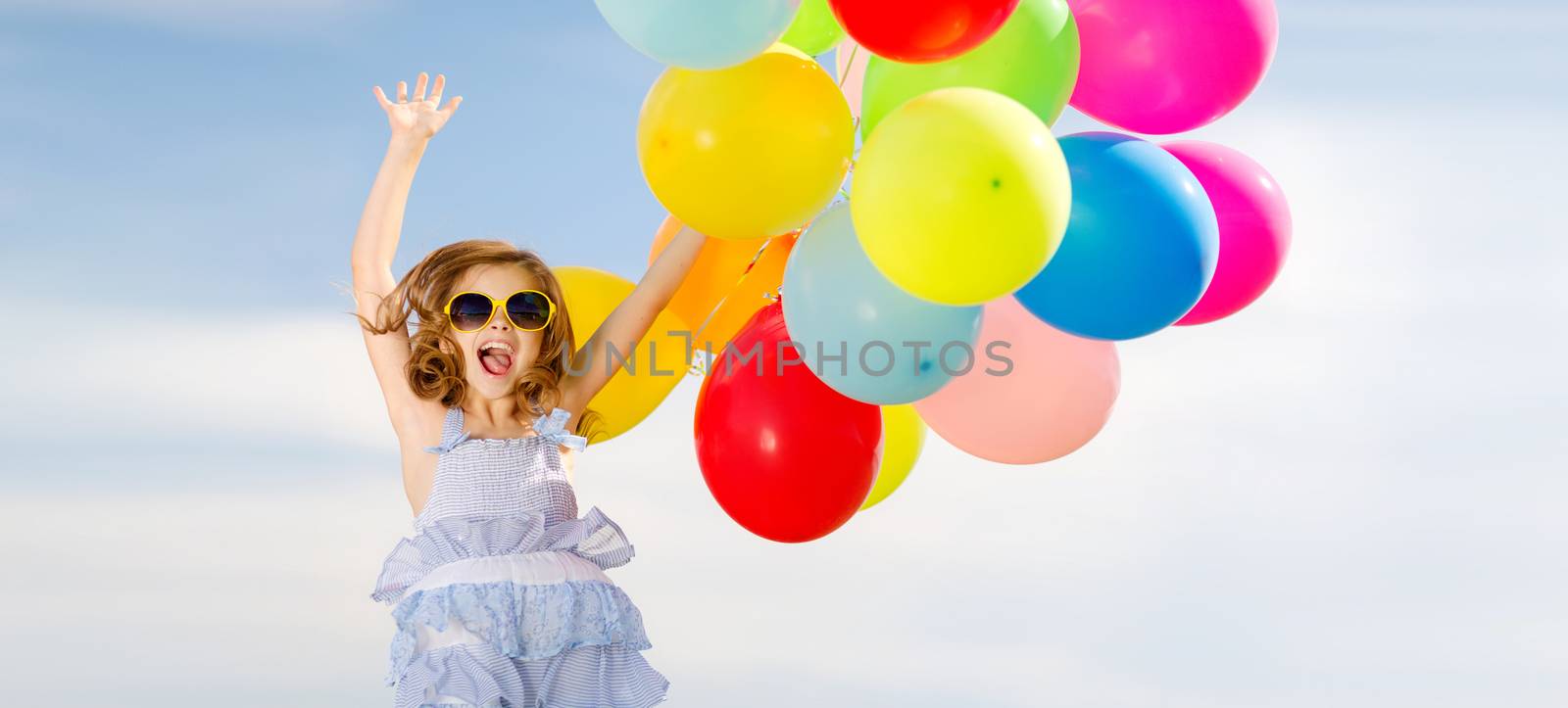 summer holidays, celebration, children and people concept - happy jumping girl with colorful balloons outdoors