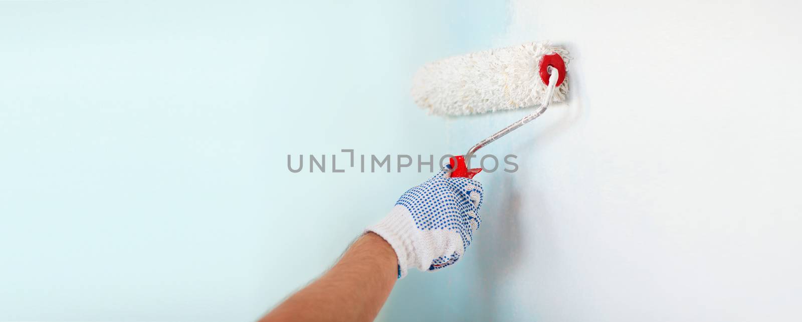 close up of male in gloves painting wall by dolgachov