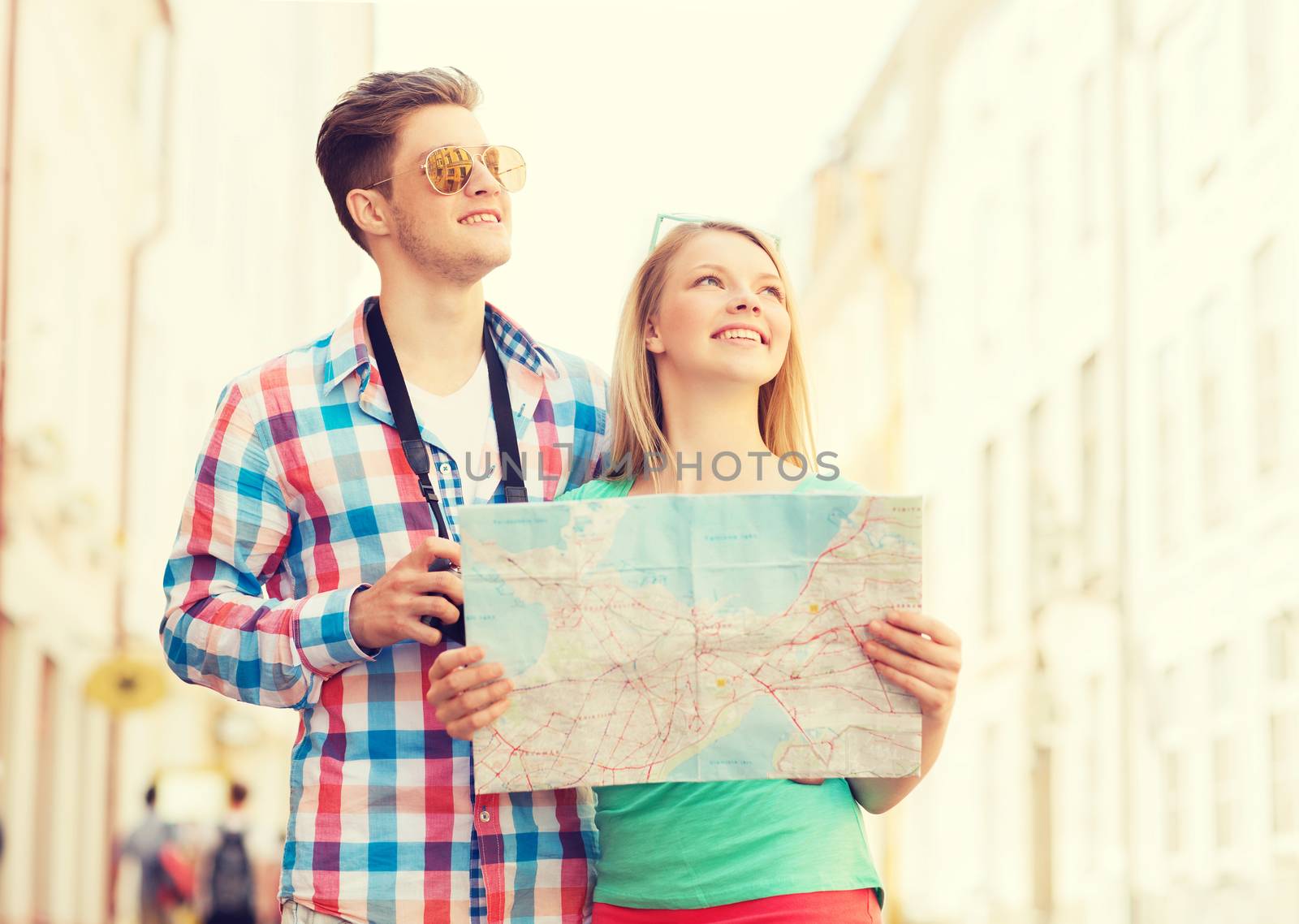 travel, vacation, technology and friendship concept - smiling couple with map and photo camera exploring city