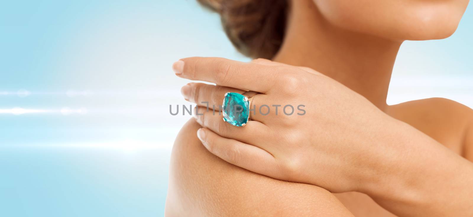 closeup of woman hand with big blue cocktail ring by dolgachov