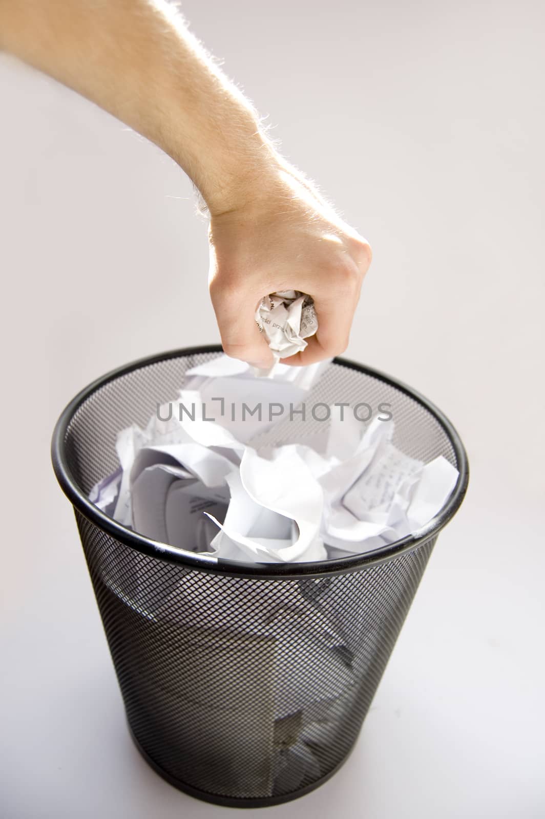 Garbage conceptual image. Man throws paper into a full garbage.