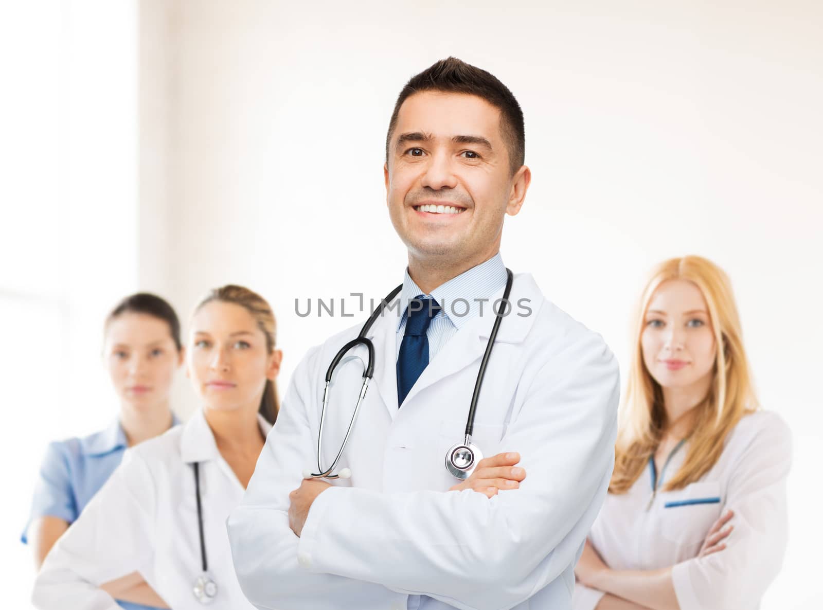 smiling male doctor in white coat at hospital by dolgachov