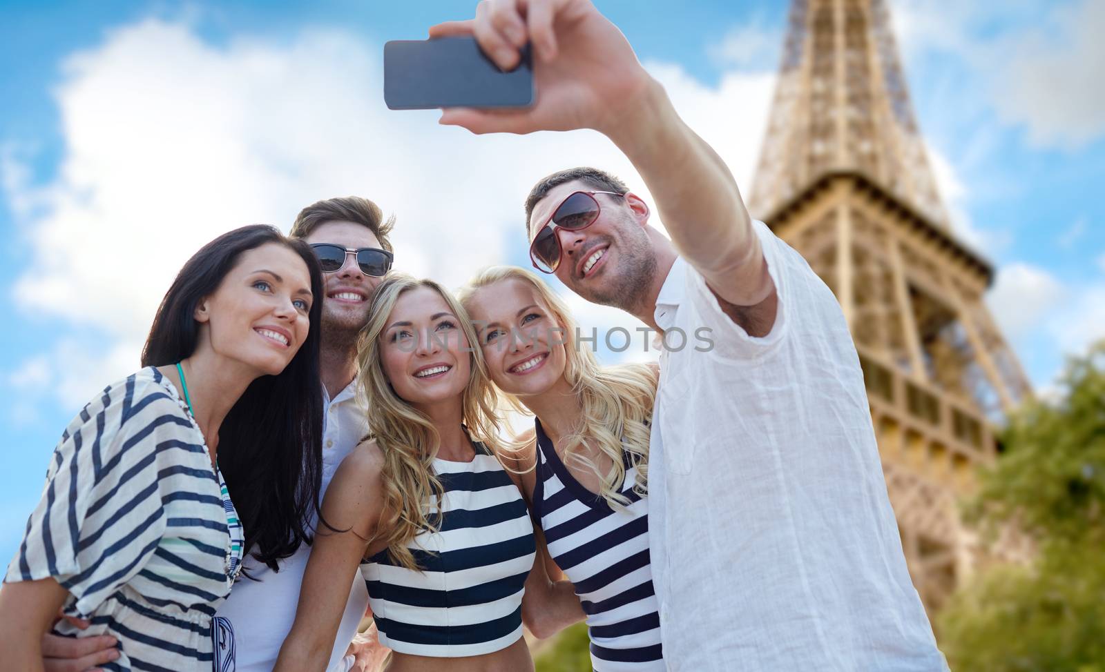 summer, france, tourism, technology and people concept - group of smiling friends taking selfie with smartphone over eiffel tower in paris background